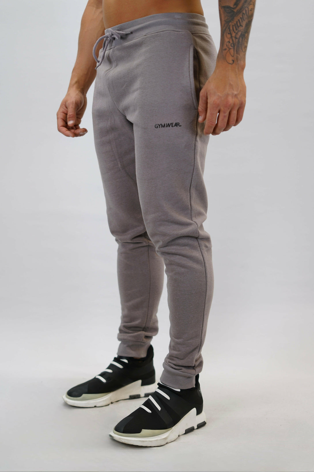 Bekväma JOGGER RAY i premium borstad bomull. Elastisk midja med dragsko, praktiska fickor och avsmalnande passform. Perfekt för träning och vardagsbruk. I färgen zink med Gymwear  logga på vänster lår.