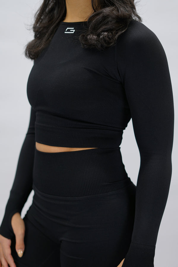 Svart Celia Long-Sleeve Crop Top, en cropped långärmad träningströja med G-symbol på framsidan och Gymwear-logotyp baktill