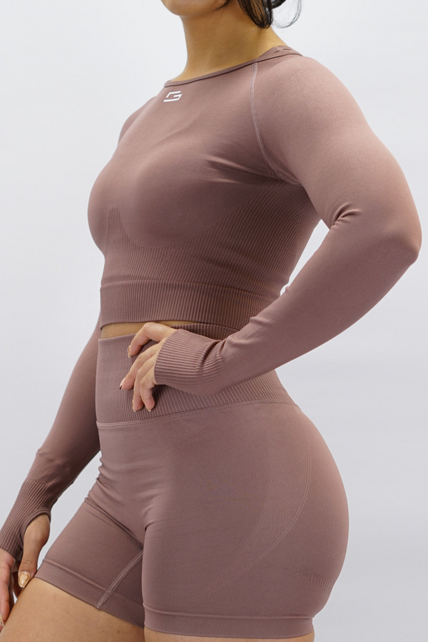 Gammaldags rosa Celia Long-Sleeve Crop Top, en cropped långärmad träningströja med G-symbol på framsidan och Gymwear-logotyp baktill