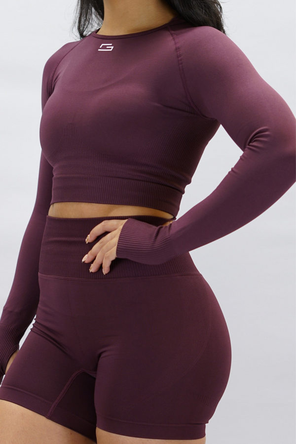 Lila Celia Long-Sleeve Crop Top, en cropped långärmad träningströja med G-symbol på framsidan och Gymwear-logotyp baktill
