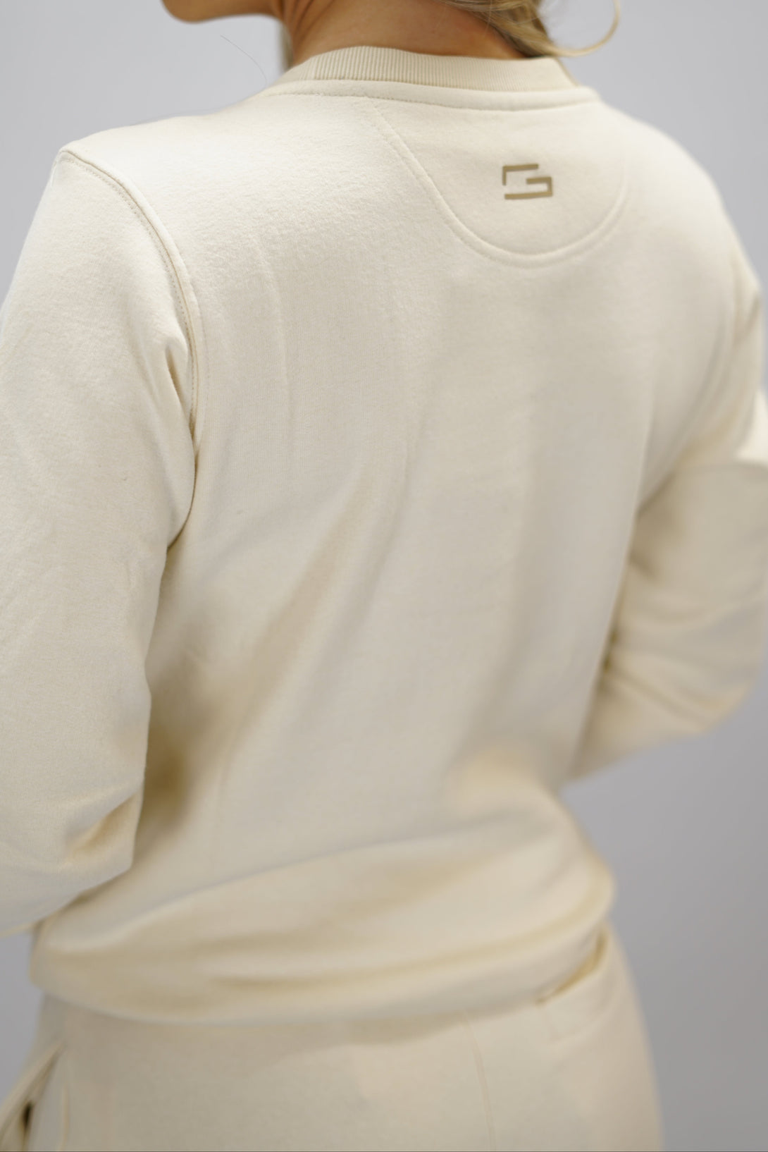 Cleo Sweatshirt dam i mjuk borstad bomull, beige färg, med stilren logga på vänster bröst. Komfortabel och snygg sweatshirt för vardagsbruk.