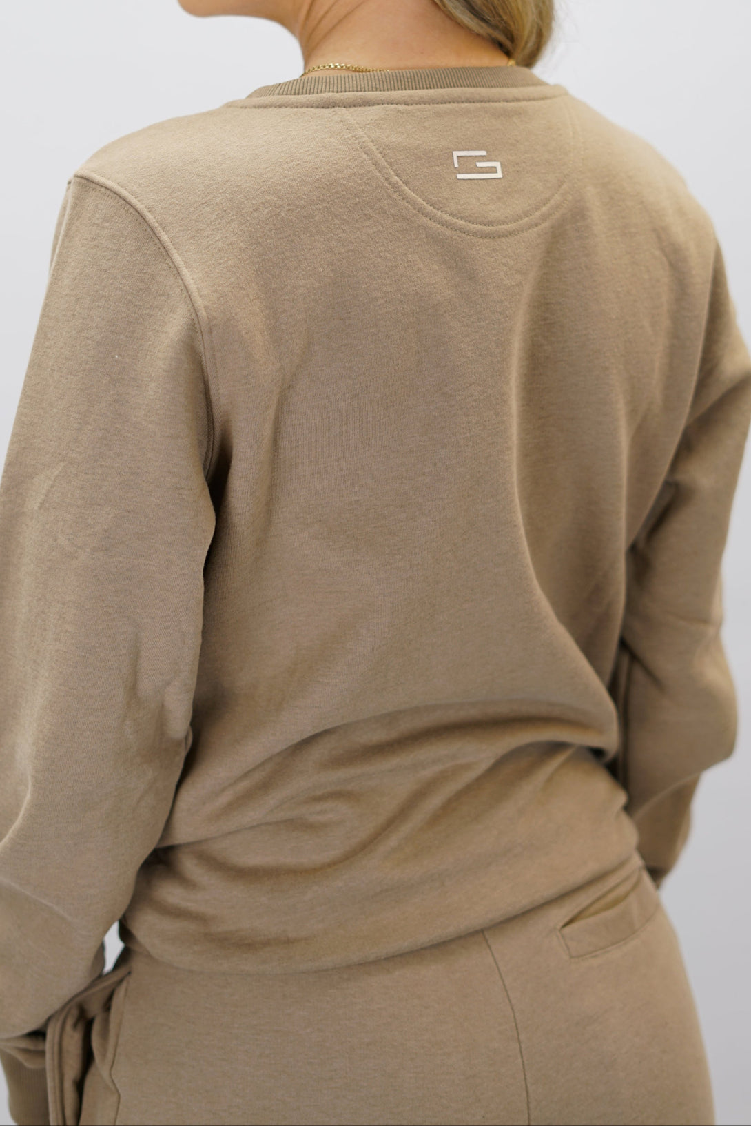 Cleo Sweatshirt dam i mjuk borstad bomull, brun färg, med stilren logga på vänster bröst och symbolen G i nacken. Komfortabel och snygg sweatshirt för vardagsbruk.