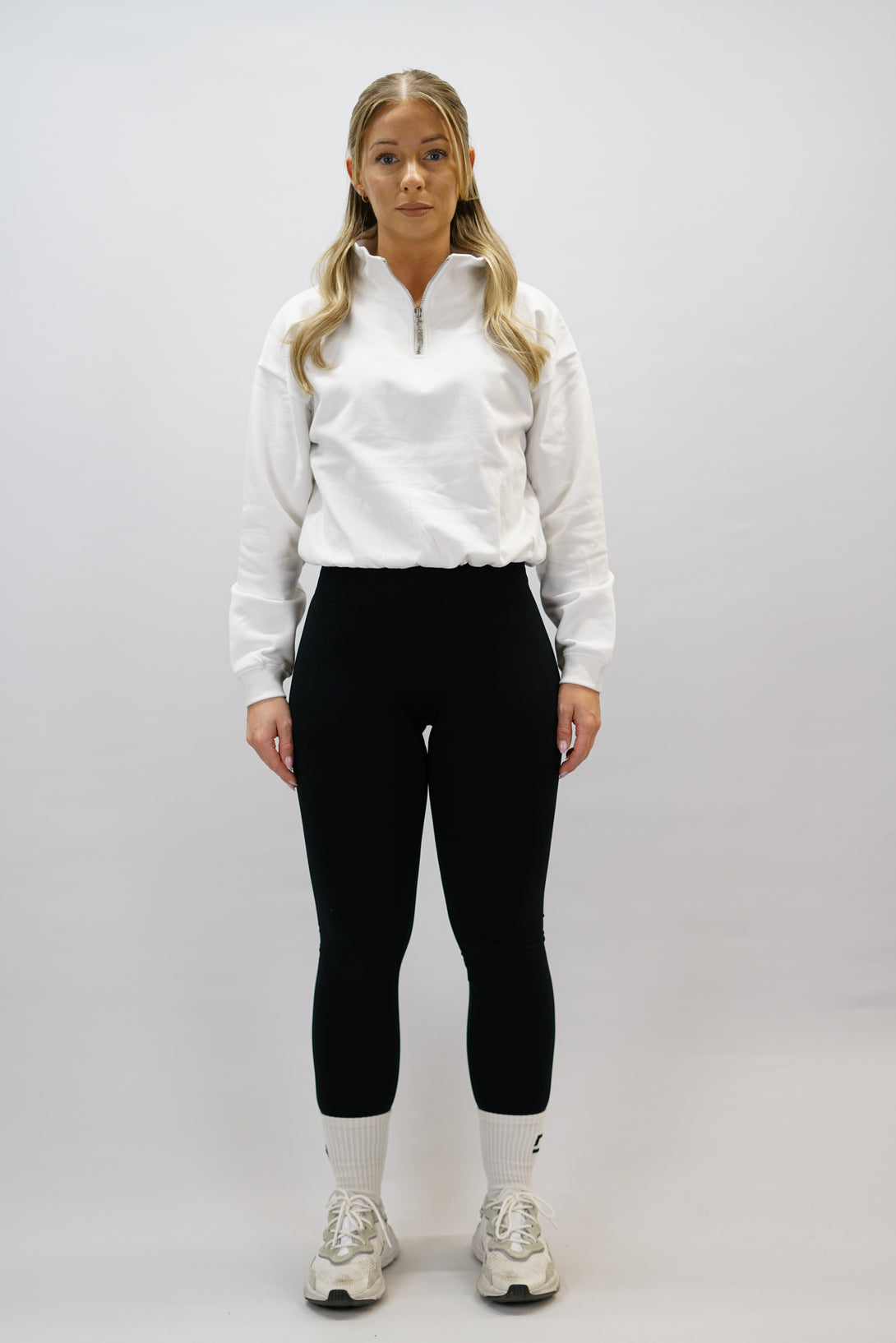 Vit Delia Half-Zip Long Sleeve, en långärmad tröja i 100% bomull med halvdragkedja vid halsen och diskret ton-i-ton Gymwear-logotyp centrerat på bröstet.