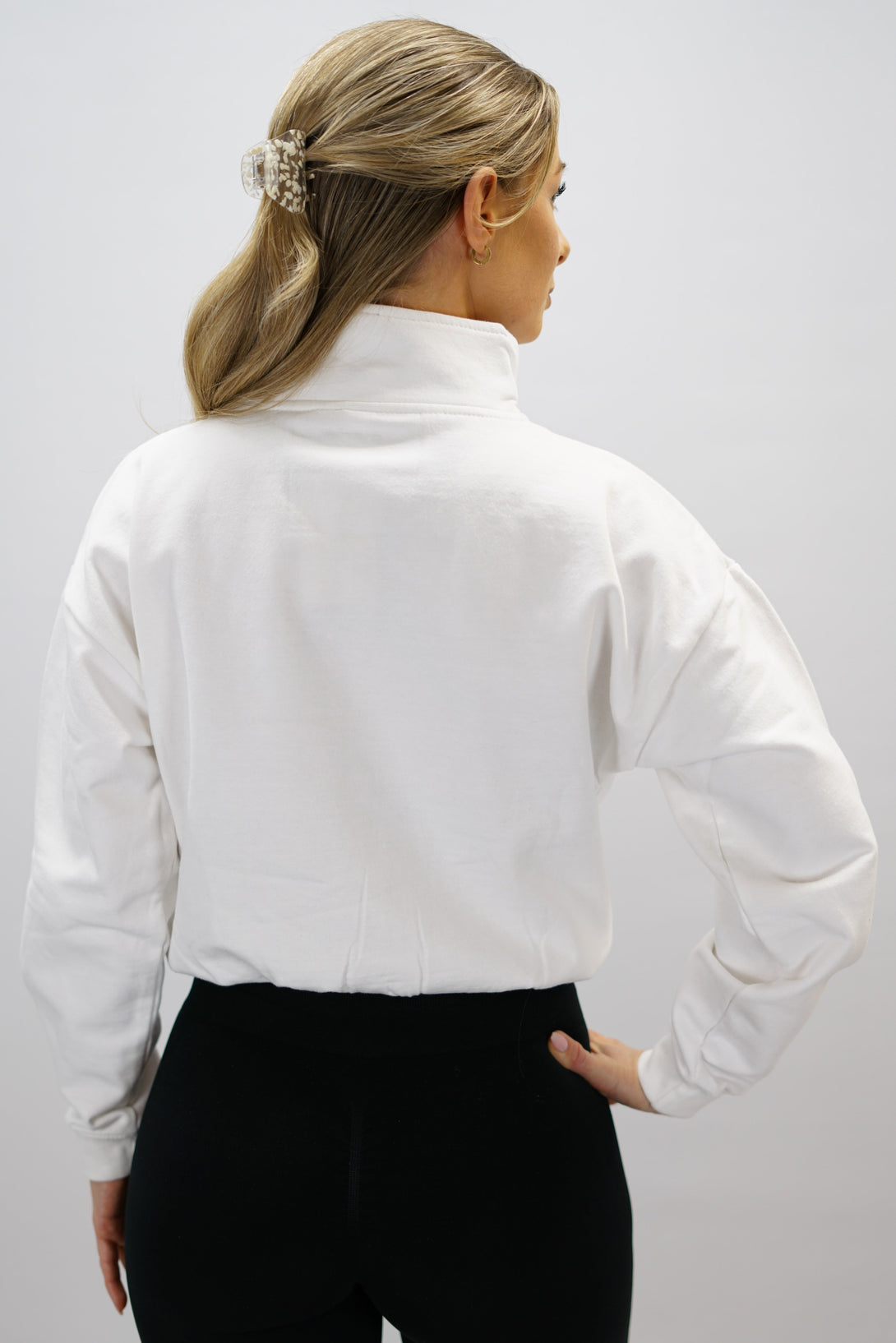 Vit Delia Half-Zip Long Sleeve, en långärmad tröja i 100% bomull med halvdragkedja vid halsen och diskret ton-i-ton Gymwear-logotyp centrerat på bröstet.