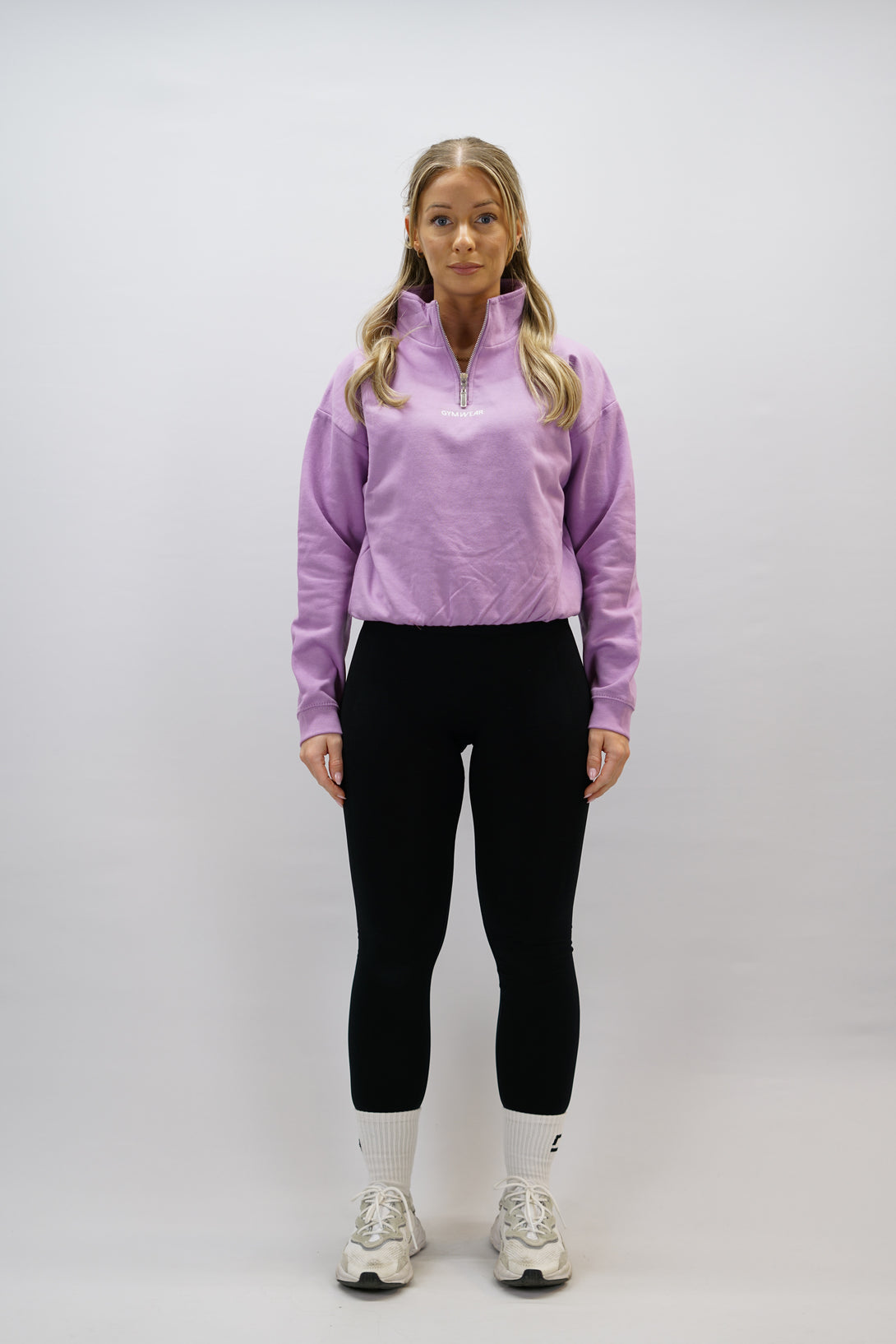 Lila Delia Half-Zip Long Sleeve, en långärmad tröja i 100% bomull med halvdragkedja vid halsen och diskret ton-i-ton Gymwear-logotyp centrerat på bröstet.