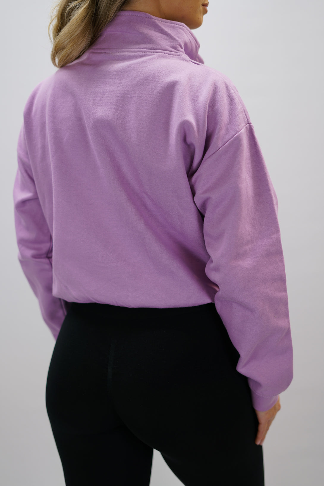 Lila Delia Half-Zip Long Sleeve, en långärmad tröja i 100% bomull med halvdragkedja vid halsen och diskret ton-i-ton Gymwear-logotyp centrerat på bröstet.