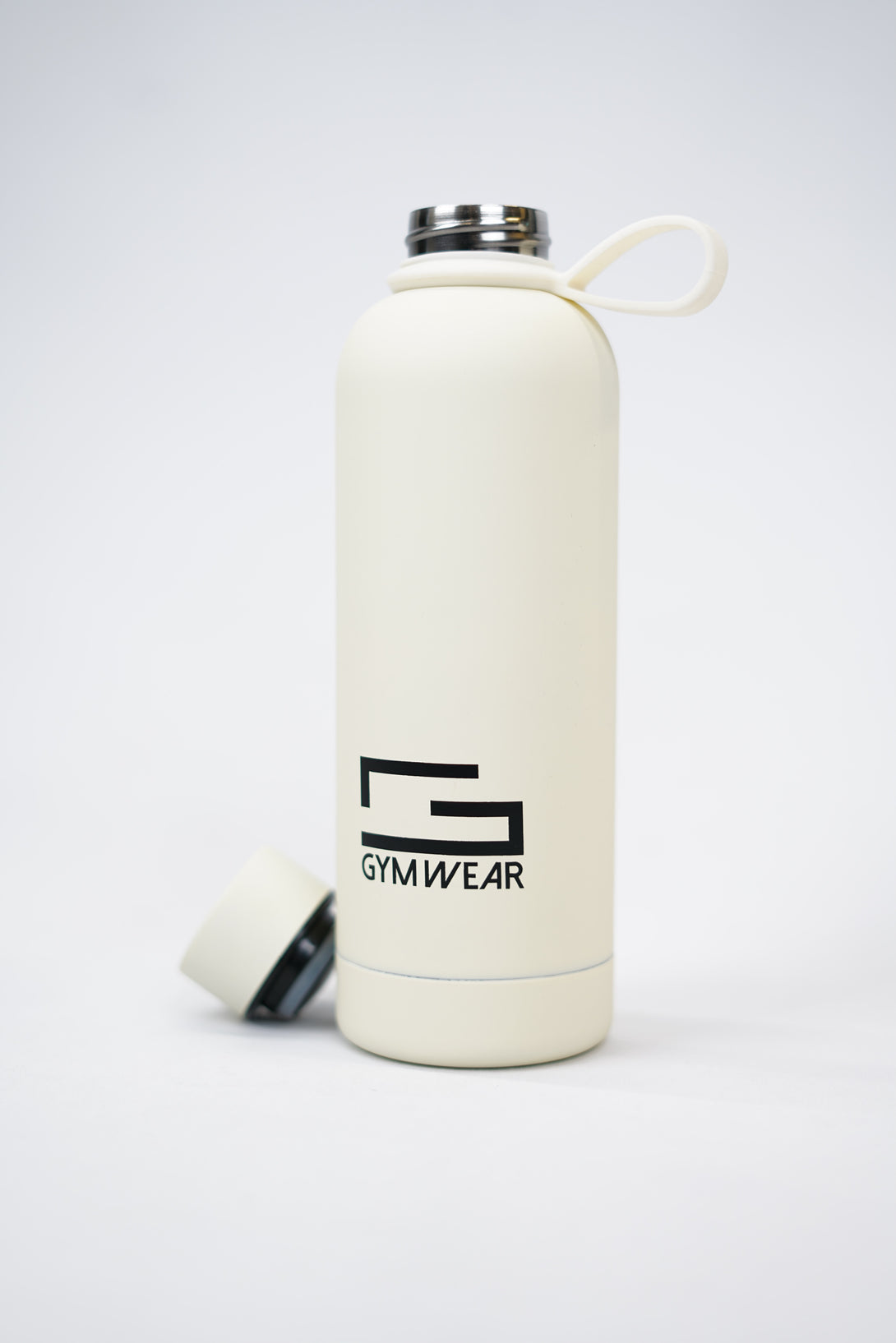 GYMWEAR Bottle 500ml, en beige rostfri vattenflaska med silikon beläggning, kapacitet 500 milliliter, med tryckt Gymwear-logotyp och symbol