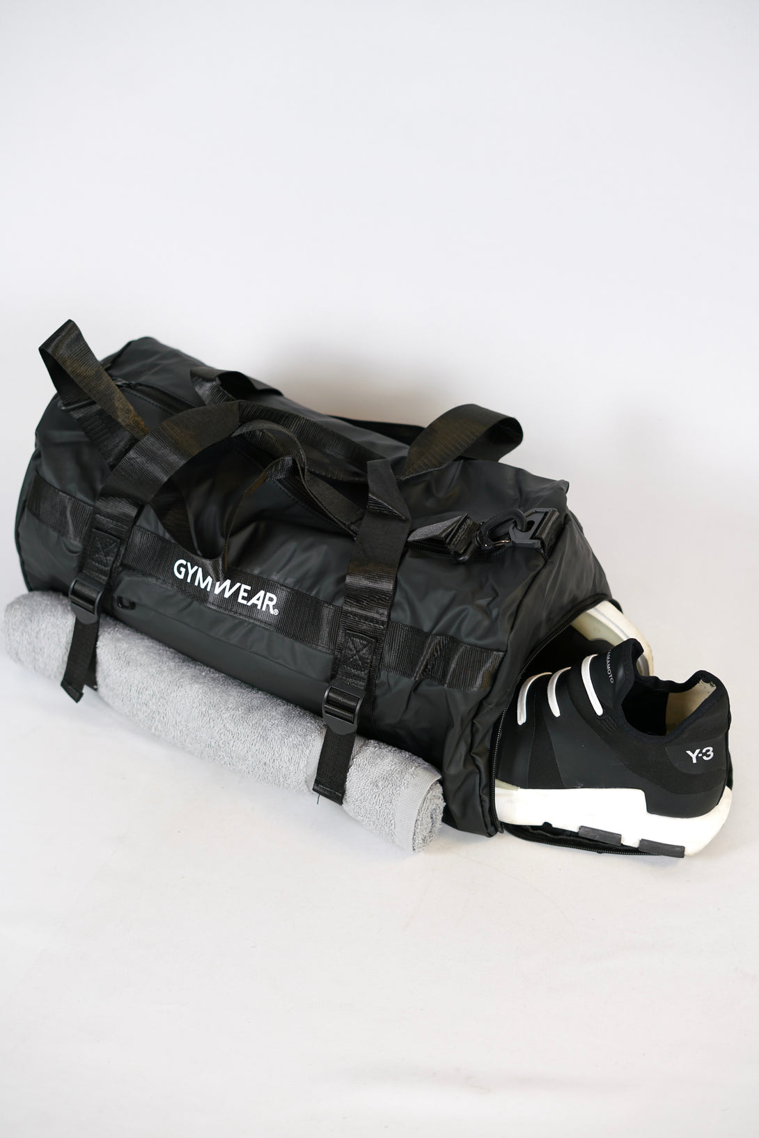 GYMWEAR Gym Bag svart, är en stilren och rymlig gym väska med smarta fack för skor, yoga matta, axelrem och vanlig handgrepp mm. Den är perfekt för att ta med sig allt som behövs till gymmet. Väskan är av hög kvalitet och tålig, vilket gör den till en bra investering för alla liten gymwear logo i center av väskan gym entusiaster.