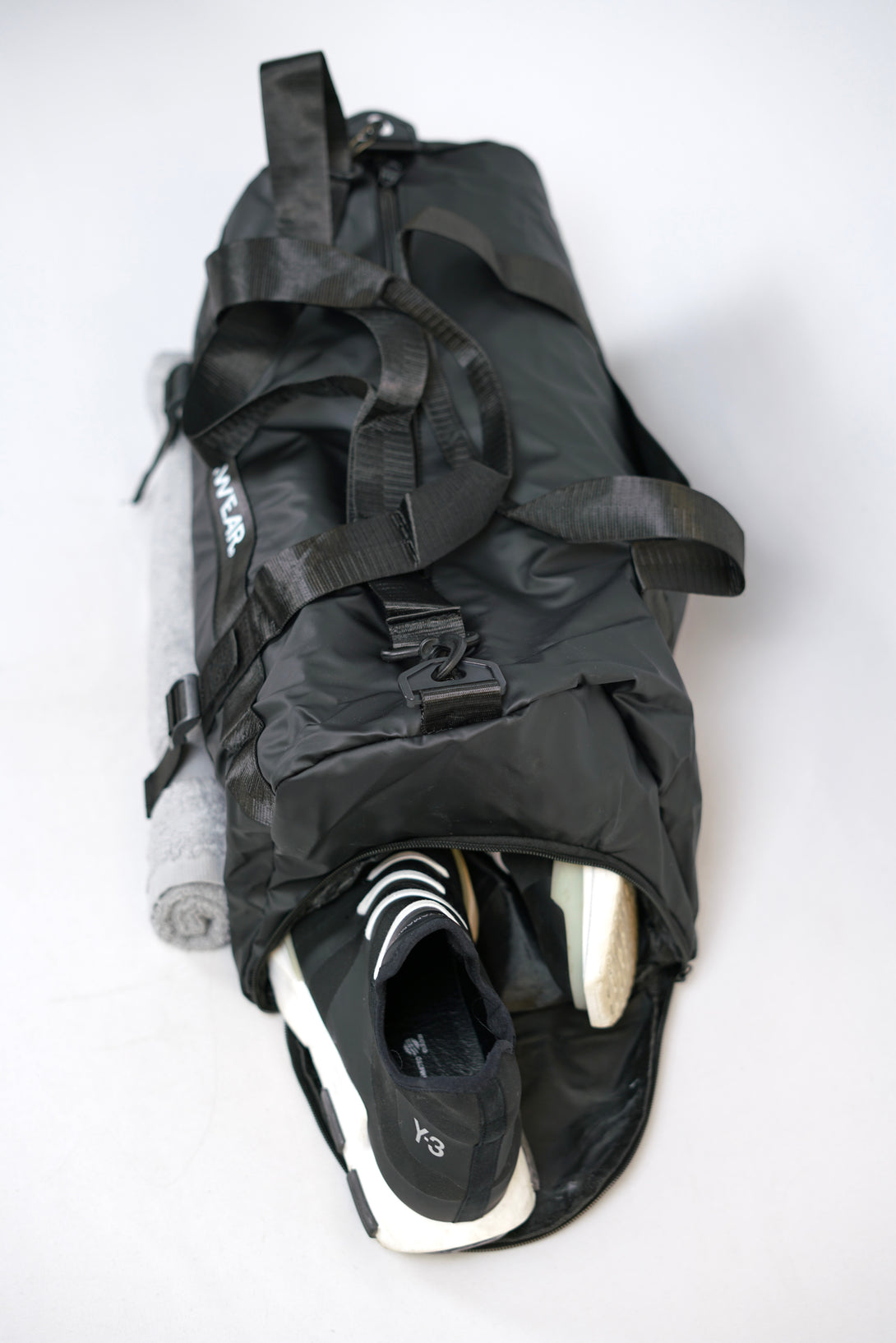 GYMWEAR Gym Bag svart, är en stilren och rymlig gym väska med smarta fack för skor, yoga matta, axelrem och vanlig handgrepp mm. Den är perfekt för att ta med sig allt som behövs till gymmet. Väskan är av hög kvalitet och tålig, vilket gör den till en bra investering för alla liten gymwear logo i center av väskan gym entusiaster.
