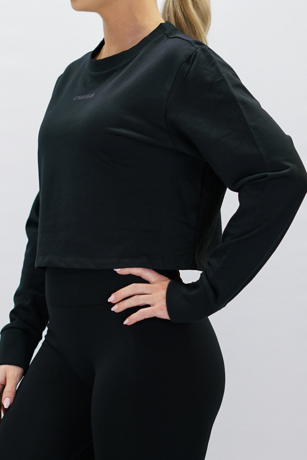 Svart Eive Long Sleeve Crop - långärmad croppad tröja i 100% bomull med ton-i-ton Gymwear-logga på framsidan