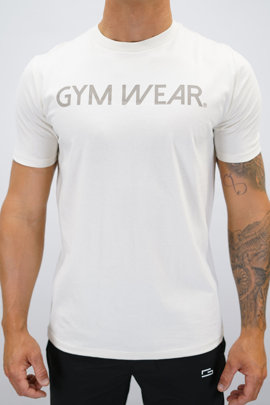 Beige Rion Organic Cotton T-shirt, en kortärmad tränings-t-shirt i ekologisk bomull med Gymwear-logotyp på bröstet och liten logga i nacken