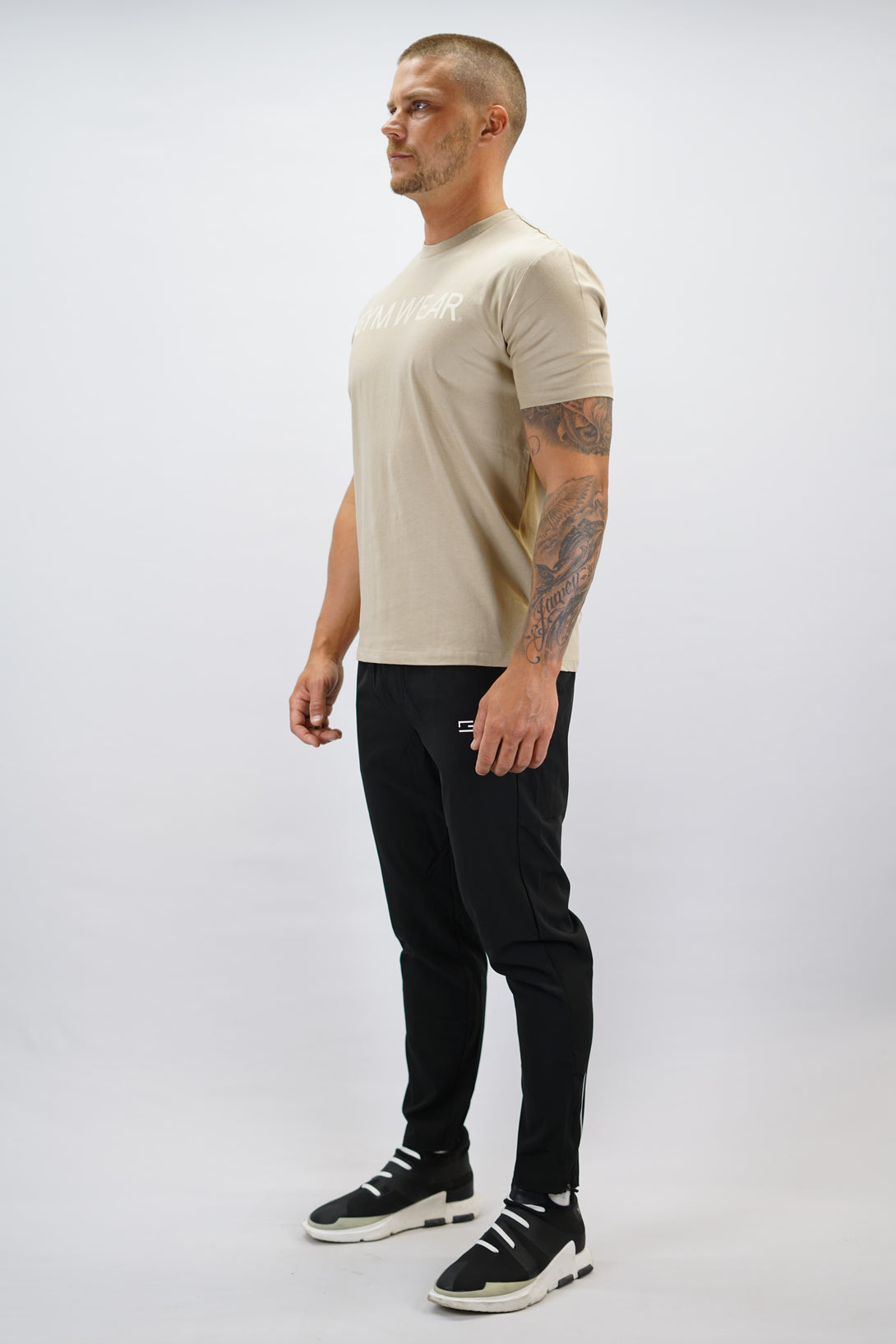 Brun+ Rion Organic Cotton T-shirt, en kortärmad tränings-t-shirt i ekologisk bomull med beige Gymwear-logotyp på bröstet och liten logga i nacken 