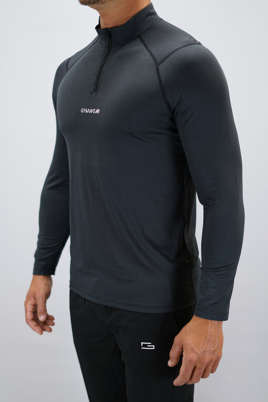 Svart Eiden Long Sleeve Half-Zip Top - funktionsmaterial långärmad träningströja med halvdragkedja och Gymwear-logga på framsidan