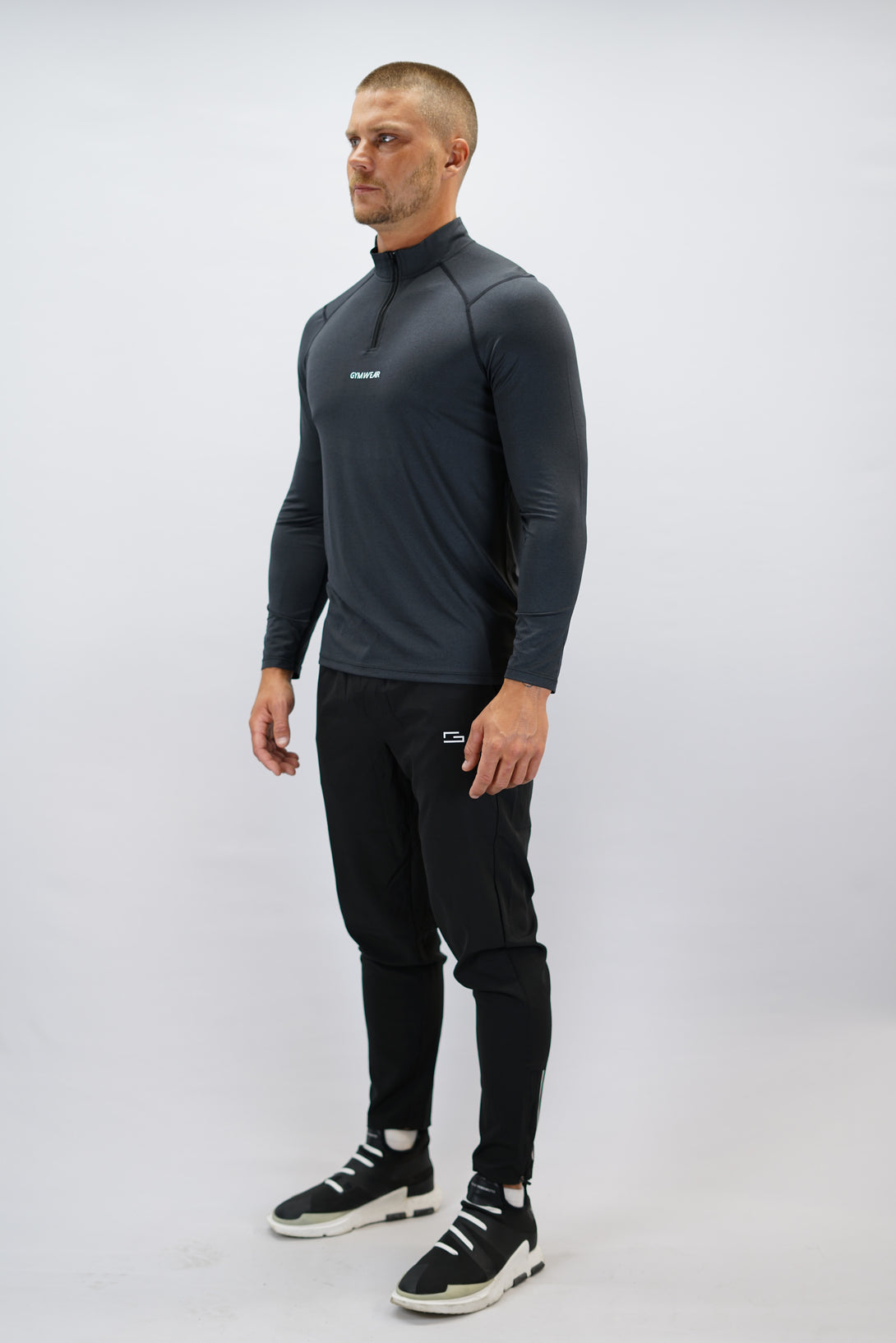 Svart Eiden Long Sleeve Half-Zip Top - funktionsmaterial långärmad träningströja med halvdragkedja och Gymwear-logga på framsidan