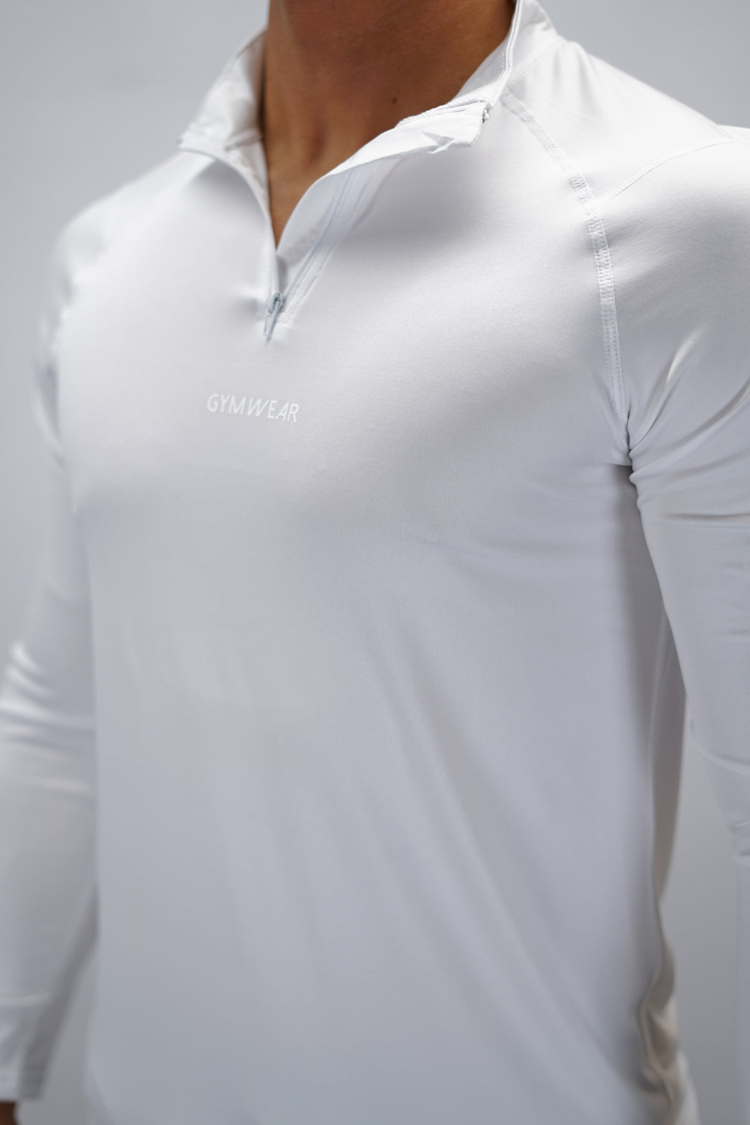 Vit Eiden Long Sleeve Half-Zip Top - funktionsmaterial långärmad träningströja med halvdragkedja och Gymwear-logga på framsidan