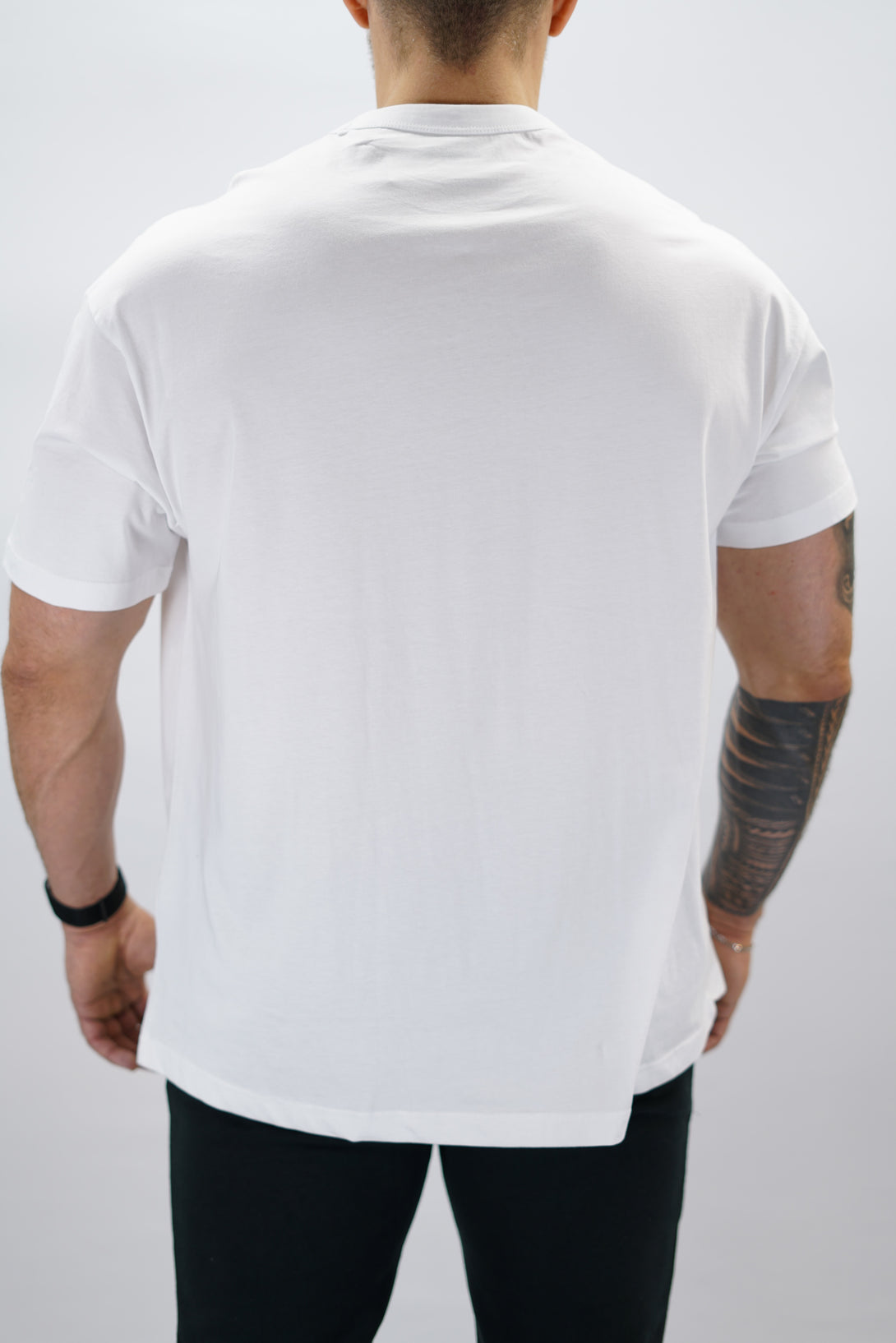 Svart Mino Organic Oversized T-Shirt, en oversized tränings-t-shirt i skönt och svalt organiskt material med Gymwear-logotyp centrerat på bröstet och G-symbol i nacken