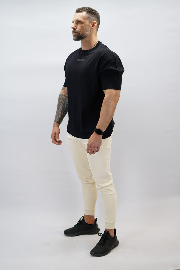 Svart Mino Organic Oversized T-Shirt, en oversized tränings-t-shirt i skönt och svalt organiskt material med Gymwear-logotyp centrerat på bröstet och G-symbol i nacken
