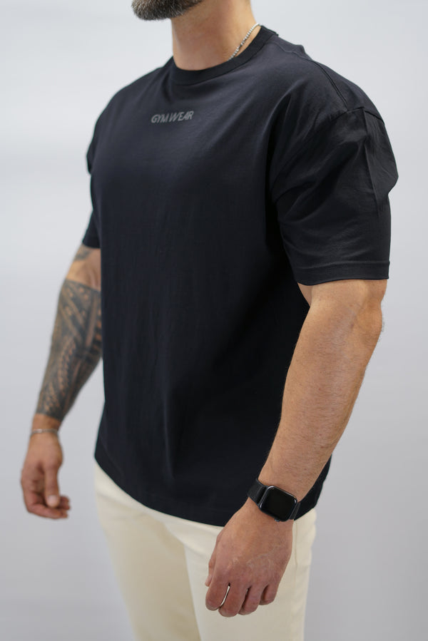 Svart Mino Organic Oversized T-Shirt, en oversized tränings-t-shirt i skönt och svalt organiskt material med Gymwear-logotyp centrerat på bröstet och G-symbol i nacken