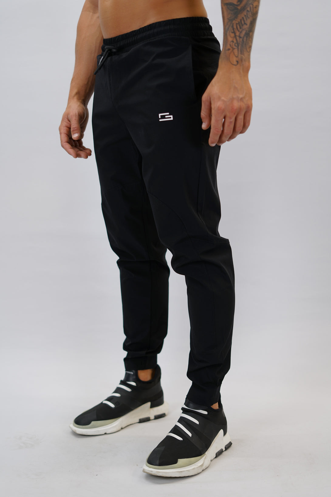Svart Zion Performance Jogger Pants - träningsbyxor i snabbtorkande material med G-symbol på vänster ben