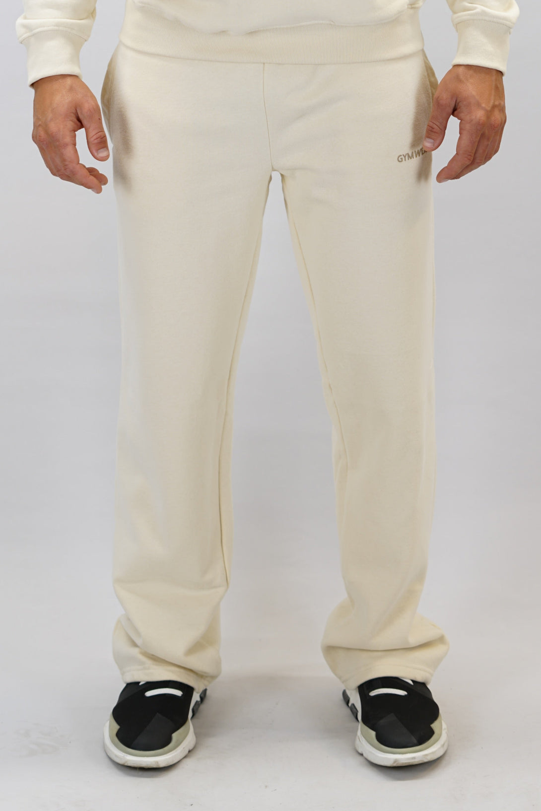 Träningsbyxor för herr med vida ben färgen är beige och Gymwear logga placerad på vänster lår nedanför fickan. Byxor som passar perfekt för träning och vardag.