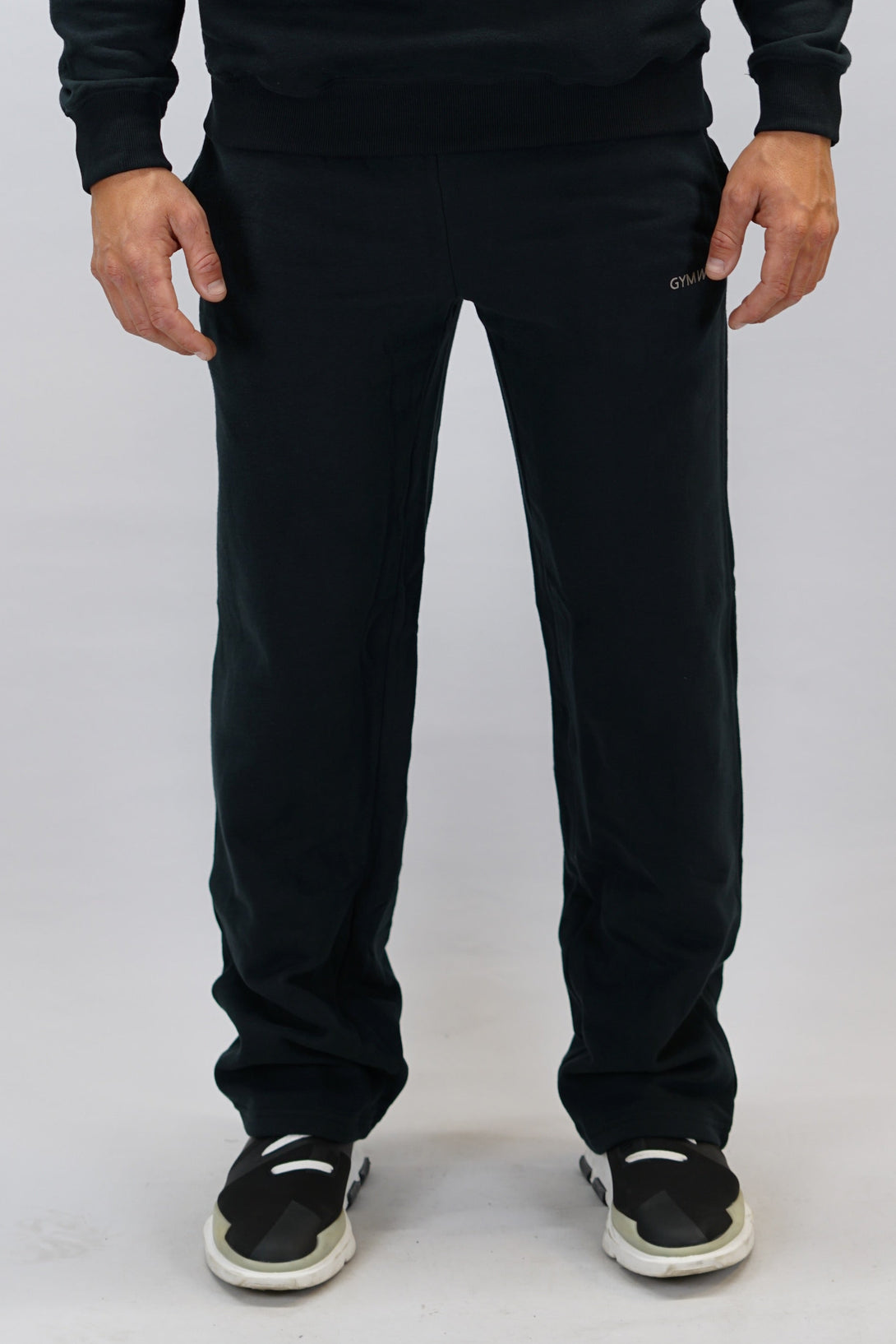 Träningsbyxor för herr med vida ben och märkes logga Gymwear placerad på vänster lår nedanför fickan. Svarta byxor som passar perfekt för träning och vardag.