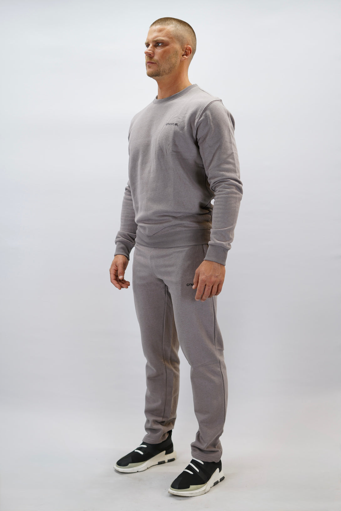 Cleo Sweatshirt herr i mjuk borstad bomull, zink färg, med stilren logga på vänster bröst. Komfortabel och snygg sweatshirt för vardagsbruk.
Till detta bär personen Bekväma JOGGER RAY i premium borstad bomull. Elastisk midja med dragsko, praktiska fickor och avsmalnande passform. Perfekt för träning och vardagsbruk. I färgen zink med Gymwear  logga på vänster lår.