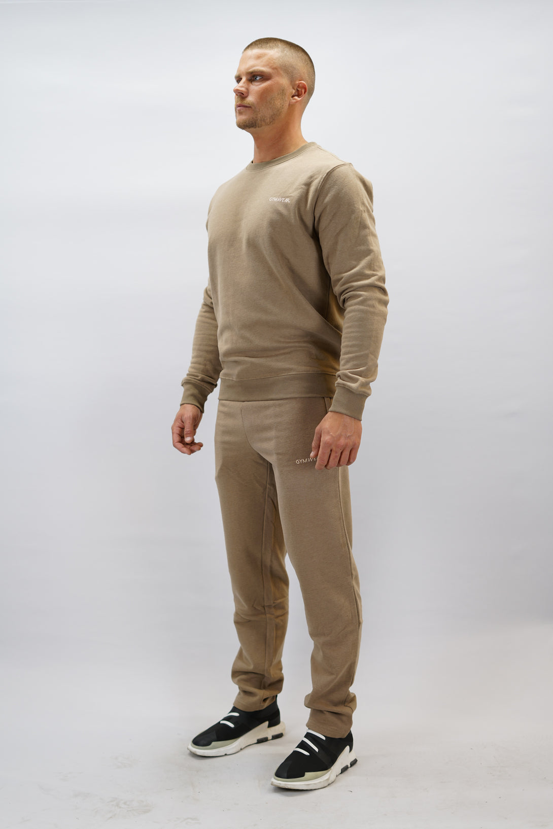 Bekväma JOGGER RAY i premium borstad bomull. Elastisk midja med dragsko, praktiska fickor och avsmalnande passform. Perfekt för träning och vardagsbruk. I färgen brun med Gymwear  logga på vänster lår.