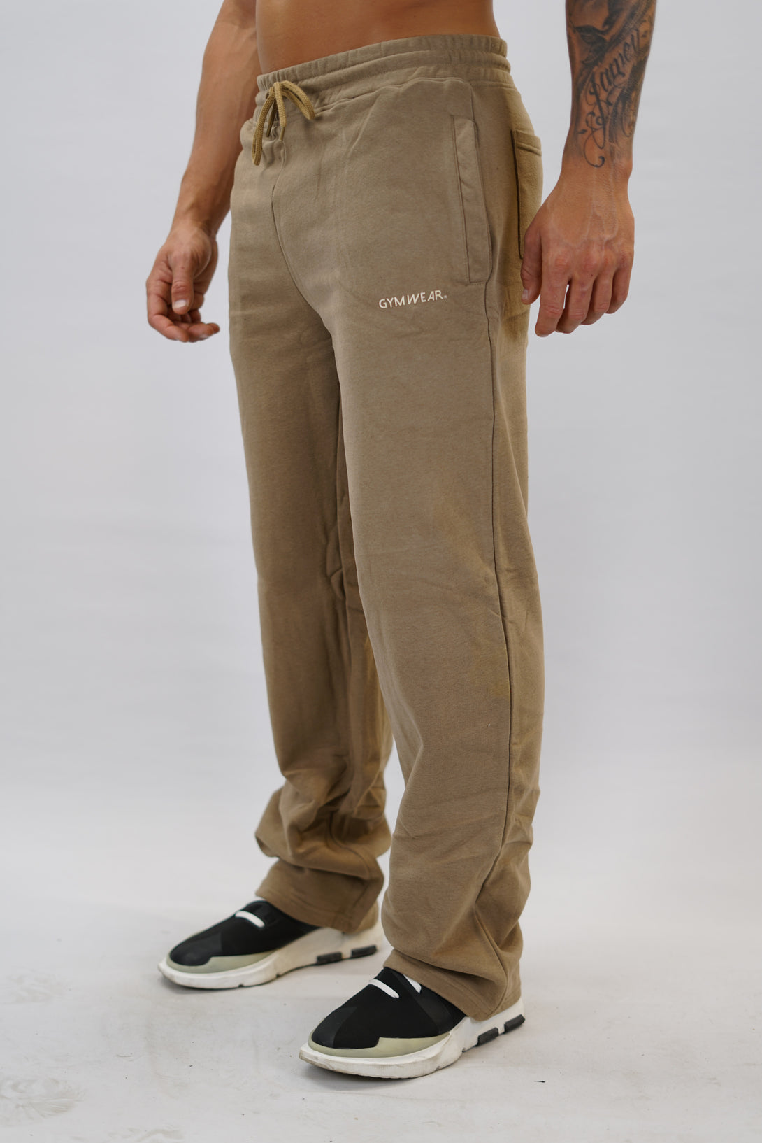 Träningsbyxor för herr med vida ben färgen är brun och Gymwear logga placerad på vänster lår nedanför fickan. Byxor som passar perfekt för träning och vardag.