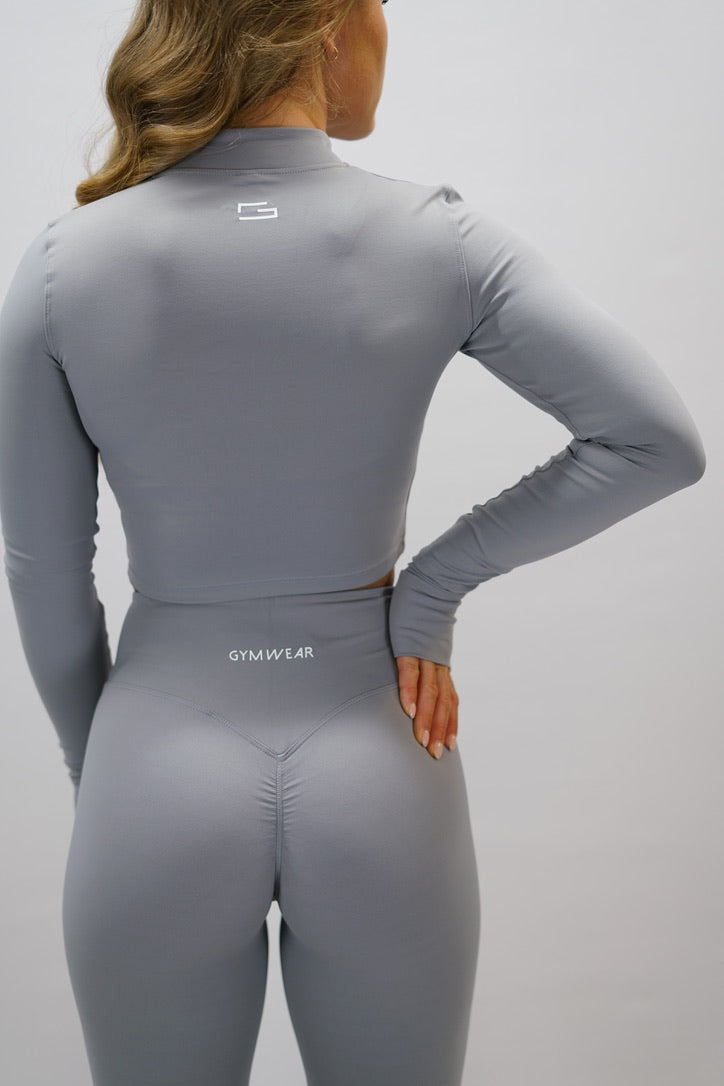 Ljusgrå Zoe Cropped Zip-up Top - cropped långärmad tröja med dragkedja, tumhål, Gymwear-logga på vänster axel och G-symbol i nacken