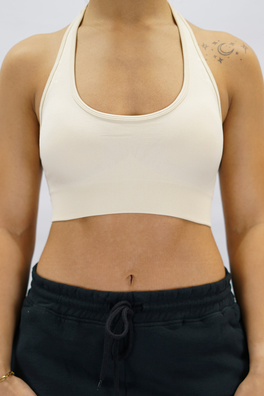 Beige Eily Halterneck Bra - sport-bh med halterneck-design och Gymwear-logga på baksidan