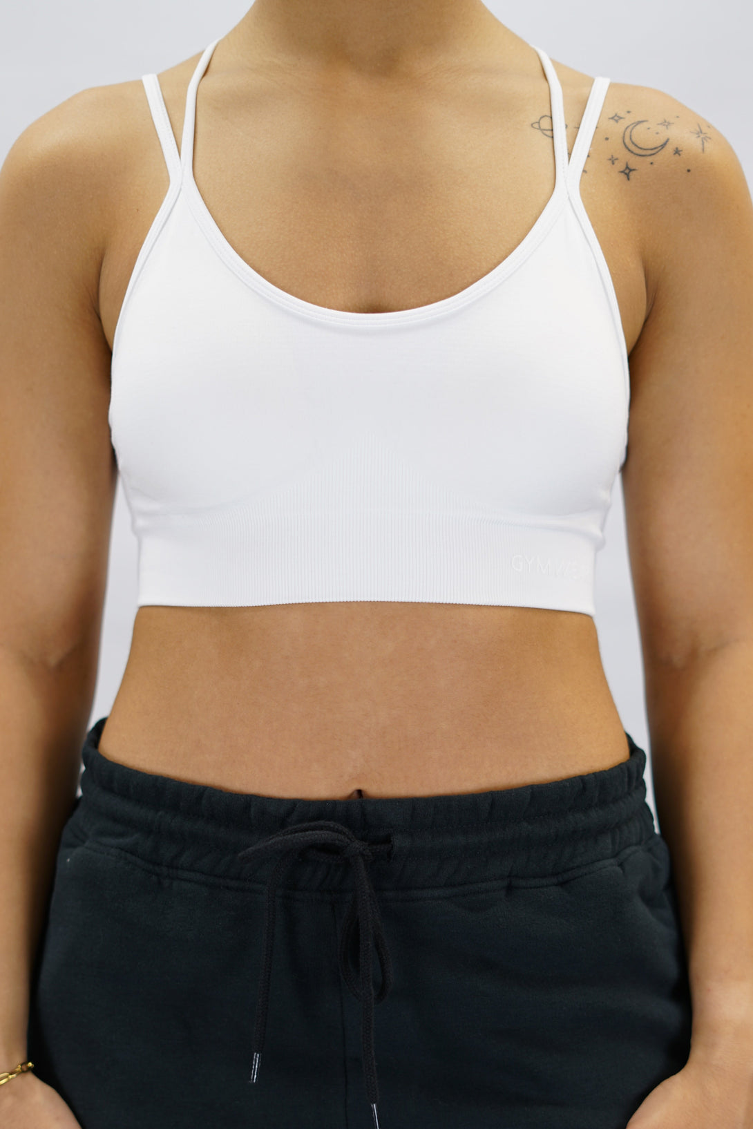 Vit Eily Cross Bra - sport-bh med korsade axelband baktill och Gymwear-logga på vänster nedre kant