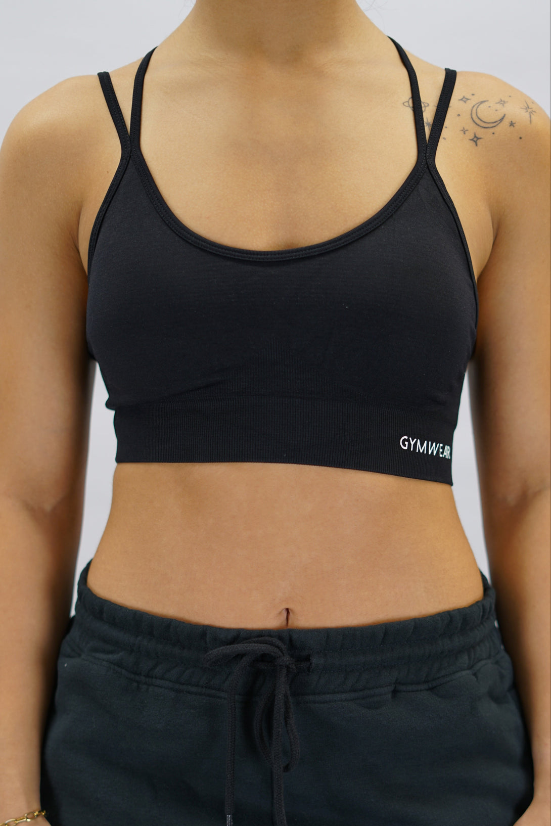 Svart Eily Cross Bra - sport-bh med korsade axelband baktill och Gymwear-logga på vänster nedre kant