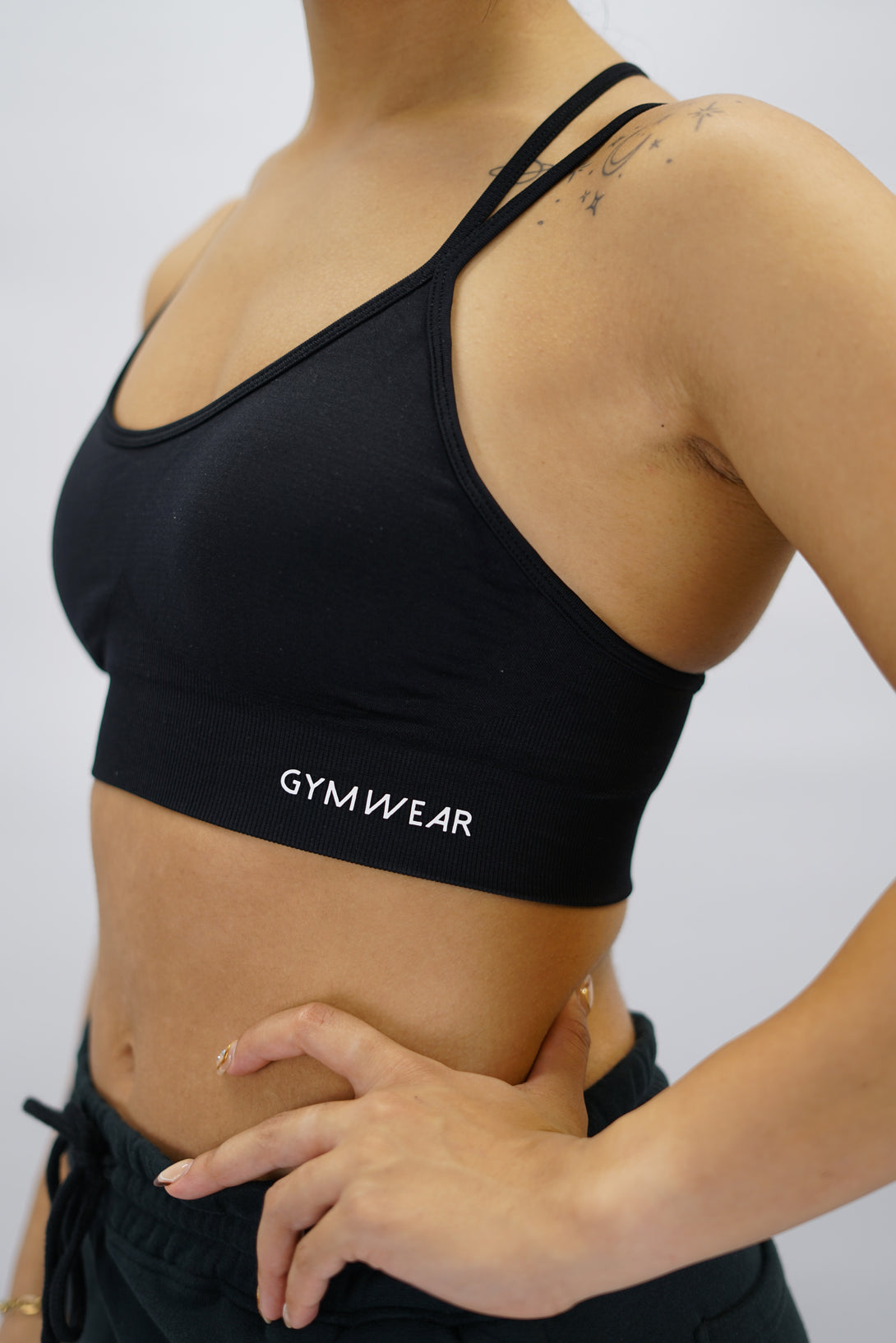 Svart Eily Cross Bra - sport-bh med korsade axelband baktill och Gymwear-logga på vänster nedre kant