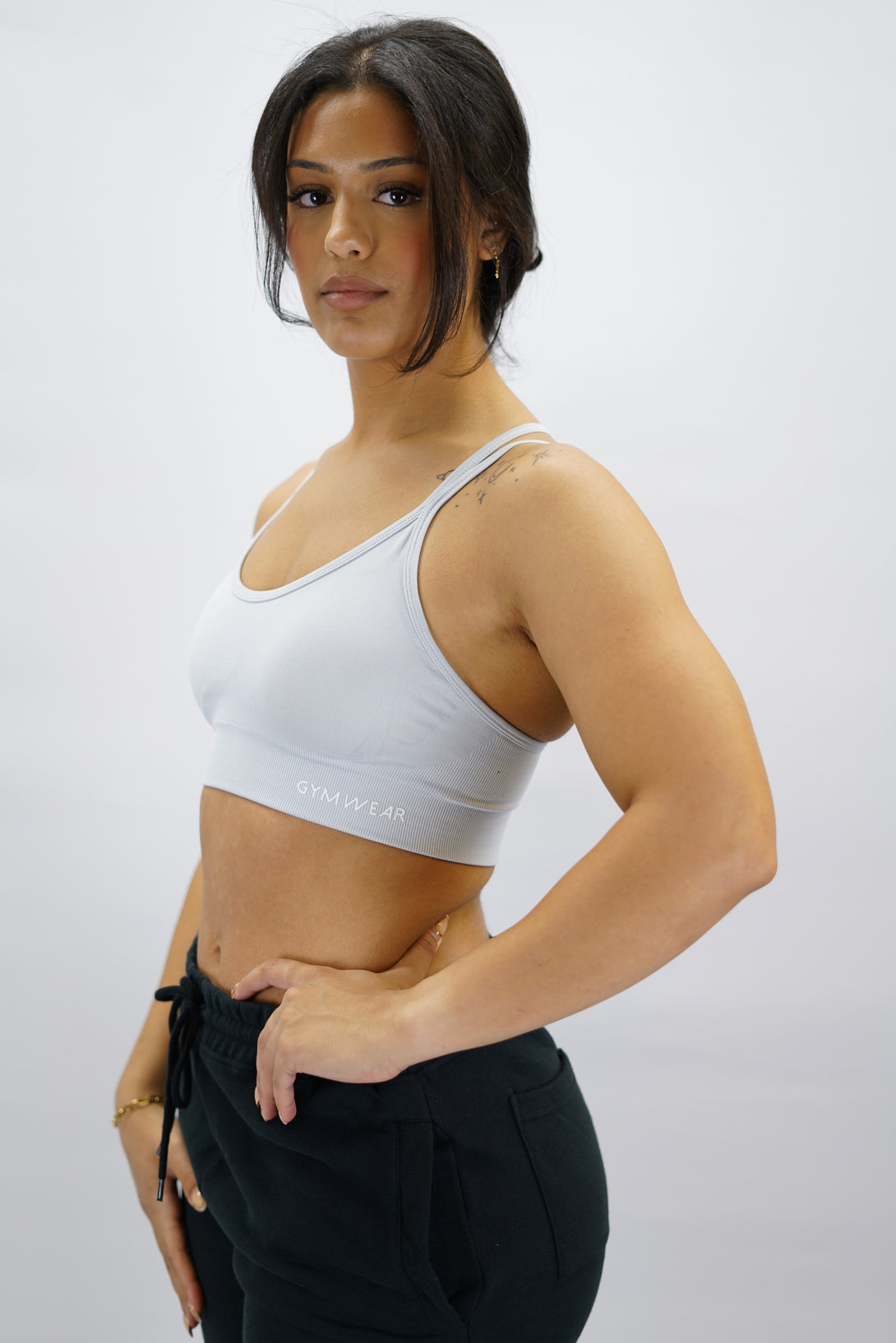 Ljusgrå Eily Cross Bra - sport-bh med korsade axelband baktill och Gymwear-logga på vänster nedre kant