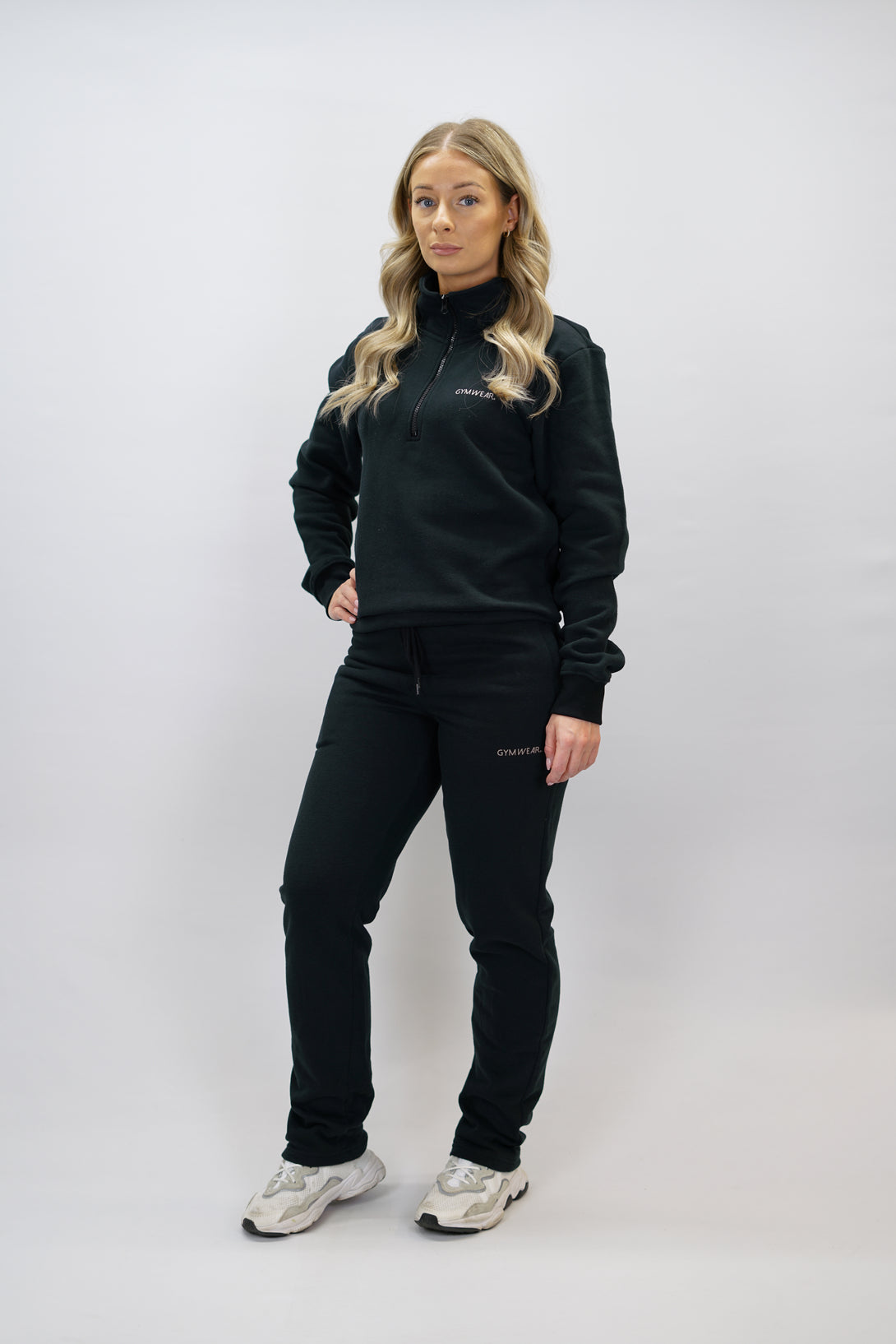 Half-Zip Sweater för dam i mjuk borstad bomull, svart färg, med logga på vänster bröst och symbol i nacken. Stilren och funktionell tröja för vardag och aktivitet.