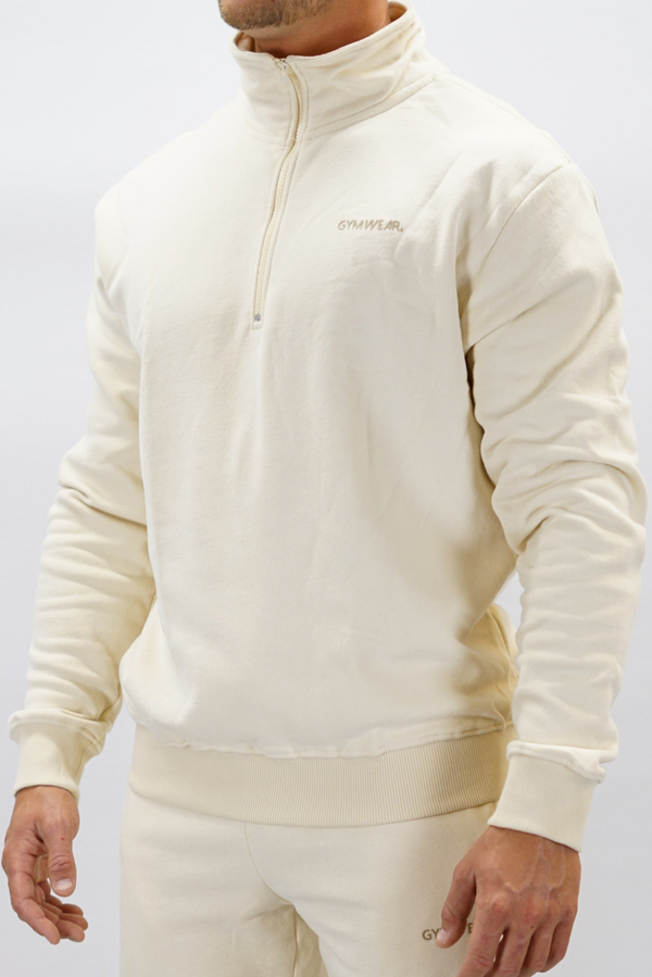 Half-Zip Sweater för herr i mjuk borstad bomull, beige färg, med Gymwear logga på vänster bröst och symbol G i nacken. Stilren och funktionell tröja för vardag och aktivitet.