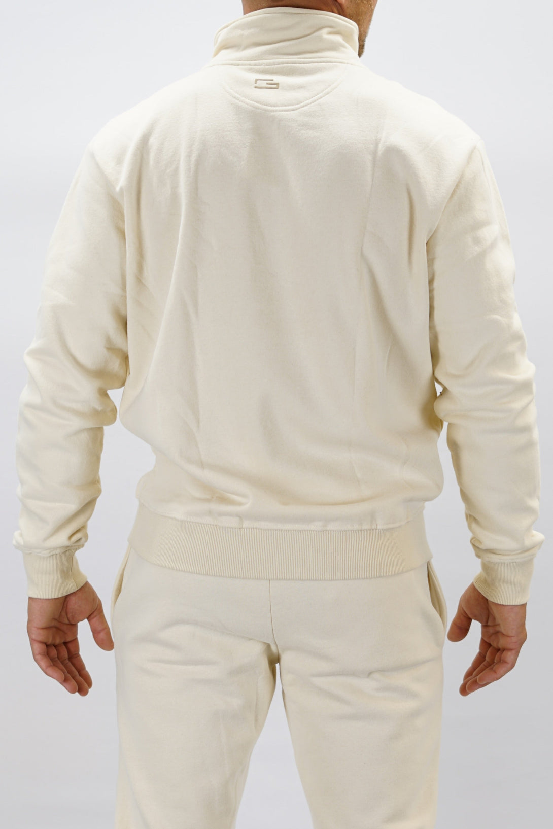 Half-Zip Sweater för herr i mjuk borstad bomull, beige färg, med Gymwear logga på vänster bröst och symbol G i nacken. Stilren och funktionell tröja för vardag och aktivitet.