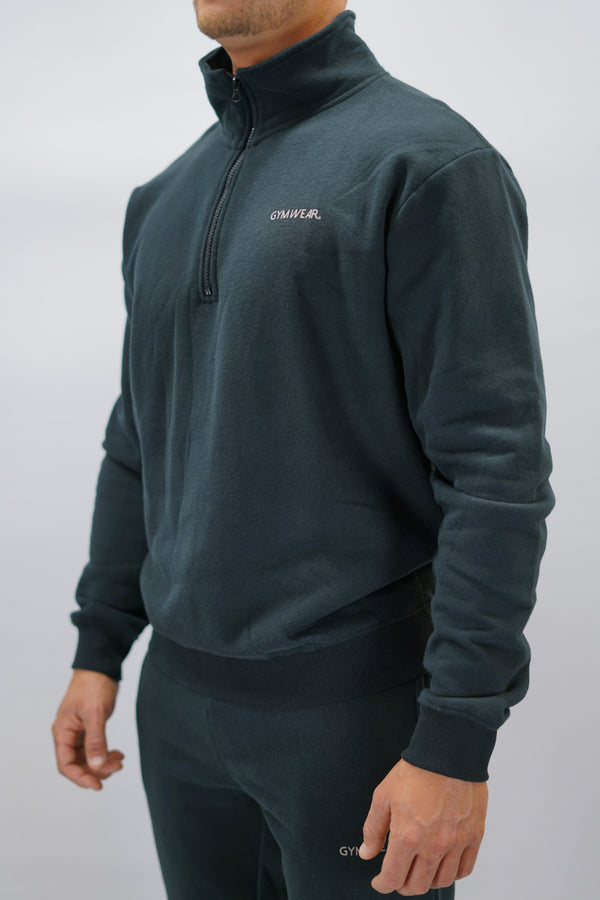 Half-Zip Sweater för herr i mjuk borstad bomull, svart färg, med Gymwear logga på vänster bröst och symbol G i nacken. Stilren och funktionell tröja för vardag och aktivitet.