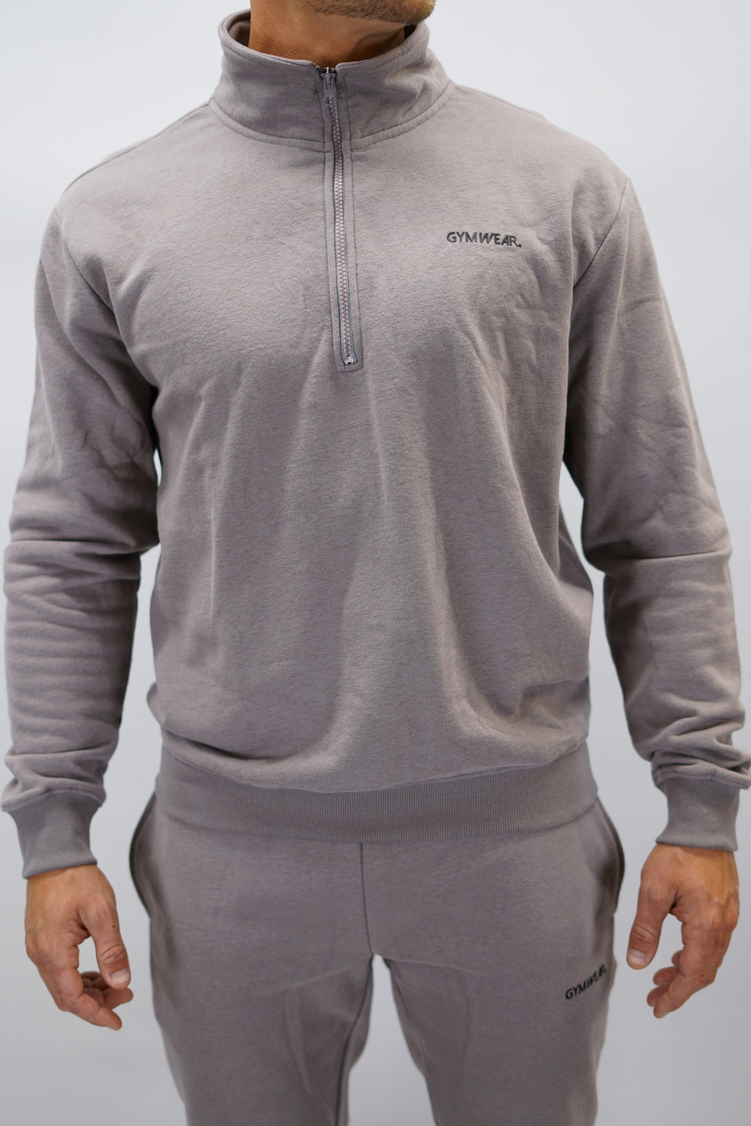 Half-Zip Sweater för herr i mjuk borstad bomull, zink färg, med Gymwear logga på vänster bröst och symbol G i nacken. Stilren och funktionell tröja för vardag och aktivitet.