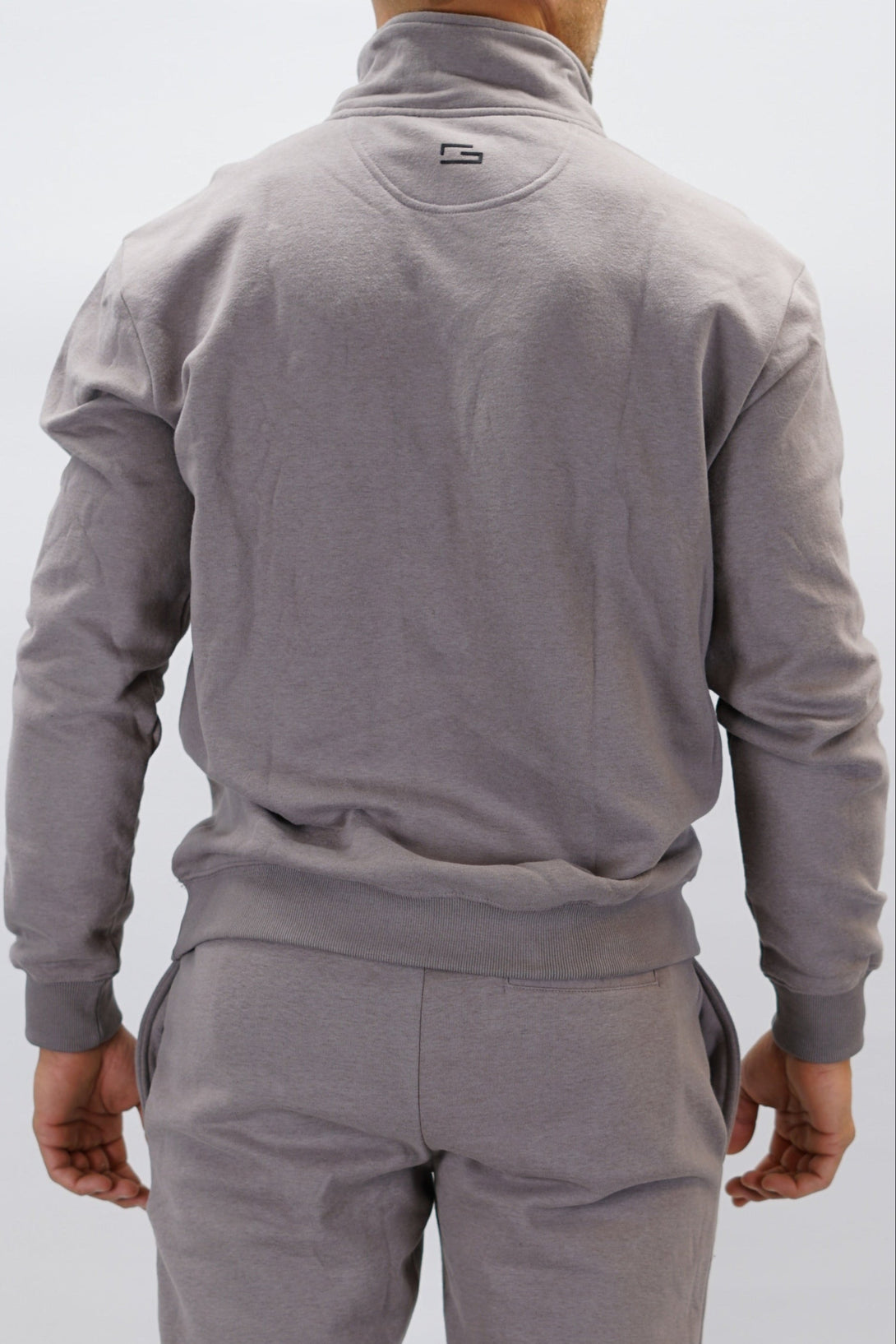 Half-Zip Sweater för herr i mjuk borstad bomull, zink färg, med Gymwear logga på vänster bröst och symbol G i nacken. Stilren och funktionell tröja för vardag och aktivitet.