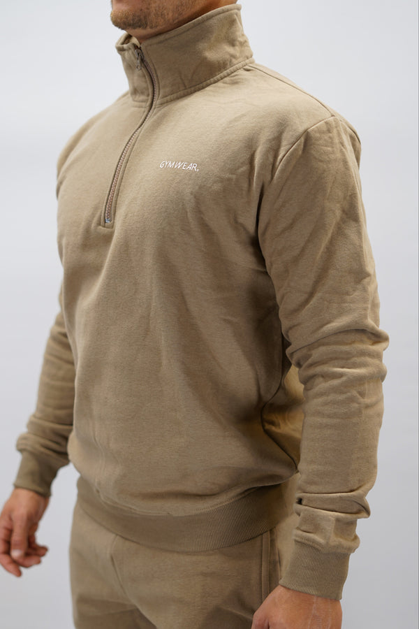 Half-Zip Sweater för herr i mjuk borstad bomull, brun färg, med Gymwear logga på vänster bröst och symbol G i nacken. Stilren och funktionell tröja för vardag och aktivitet.