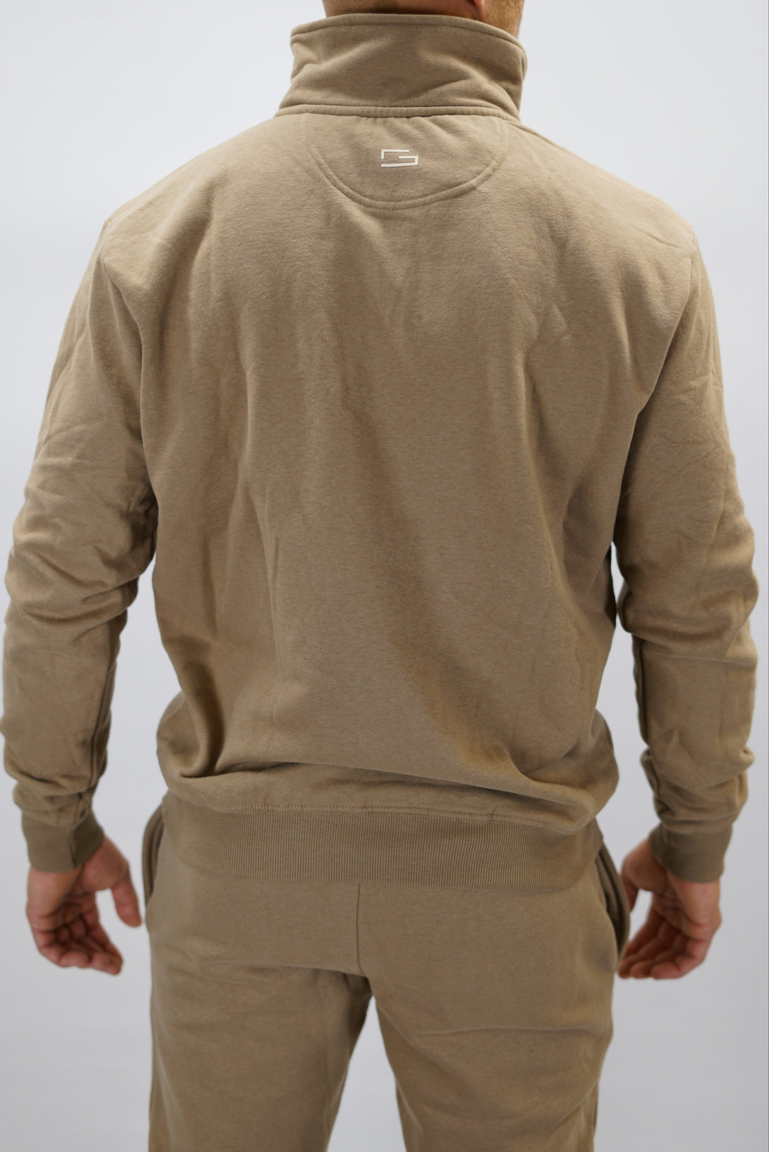 Half-Zip Sweater för herr i mjuk borstad bomull, brun färg, med Gymwear logga på vänster bröst och symbol G i nacken. Stilren och funktionell tröja för vardag och aktivitet.