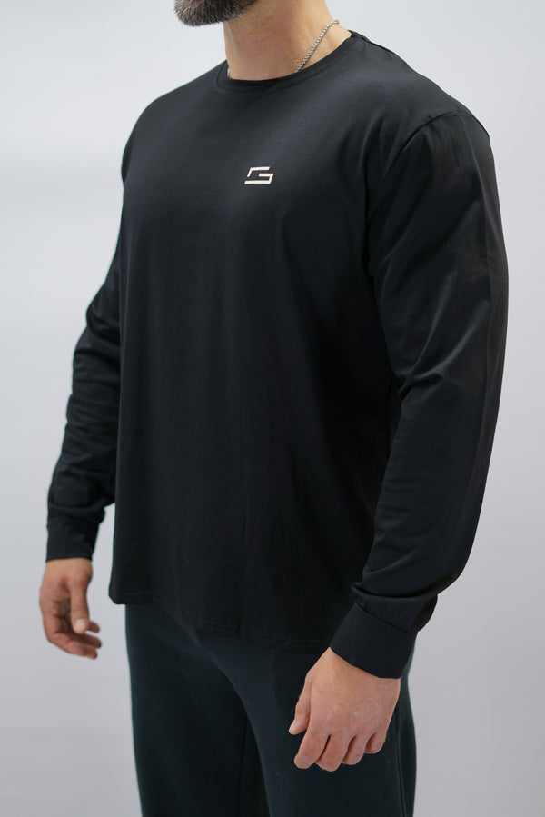 Jace Long Sleeve Shirt, en svart långärmad träningströja med relaxed fit, featuring G-symbol på bröstet och Gymwear-logotyp i nacken, gjord av andningsbara bomull-spandex material