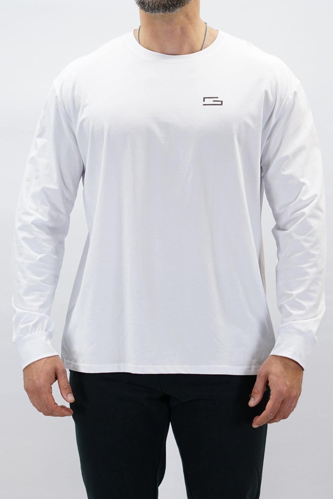 Jace Long Sleeve Shirt, en vit långärmad träningströja med relaxed fit, featuring G-symbol på bröstet och Gymwear-logotyp i nacken, gjord av andningsbara bomull-spandex material
