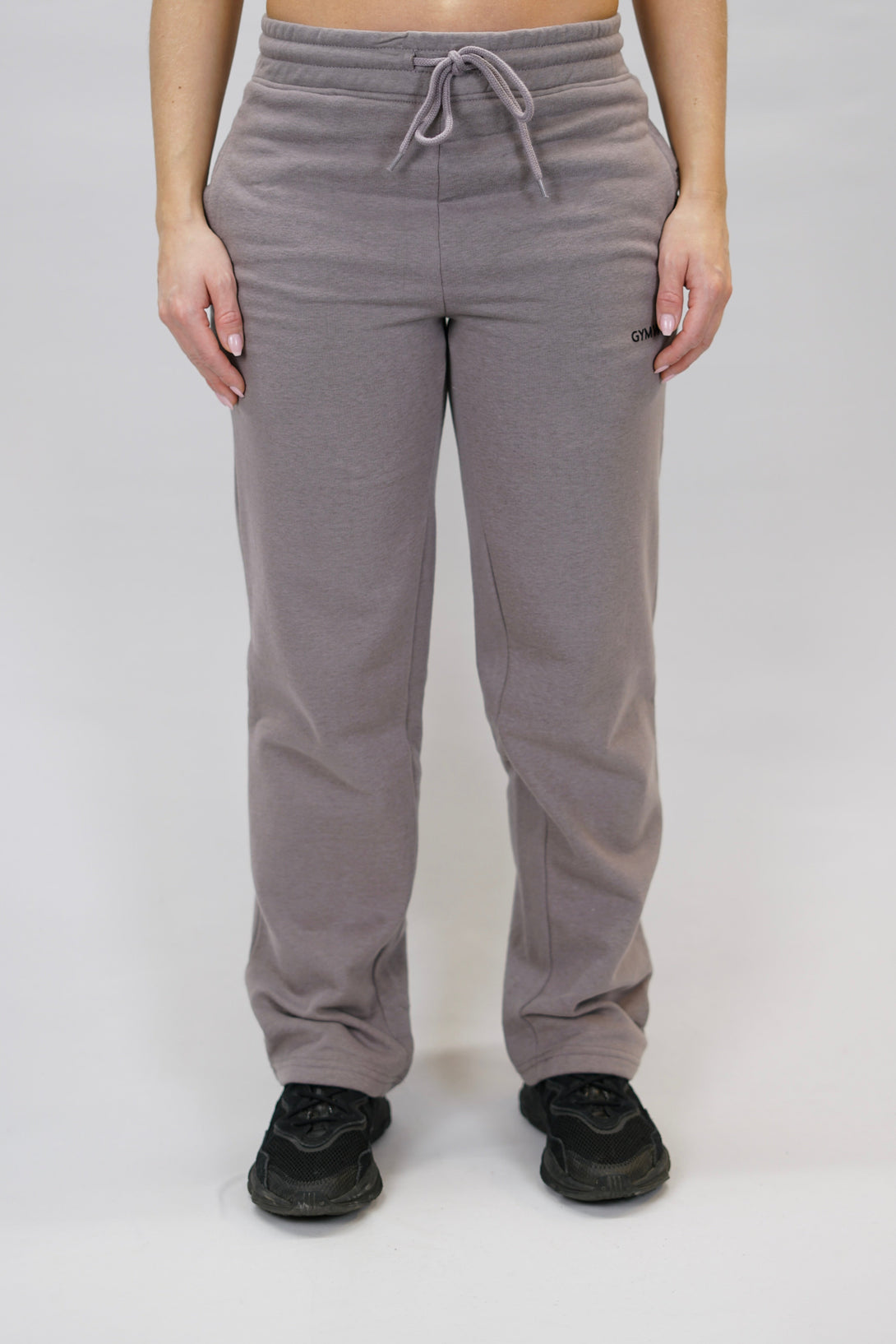 Träningsbyxor för dam med vida ben och märkes logga Gymwear placerad på vänster lår nedanför fickan. Byxor i färgen zink som passar perfekt för träning och vardag.