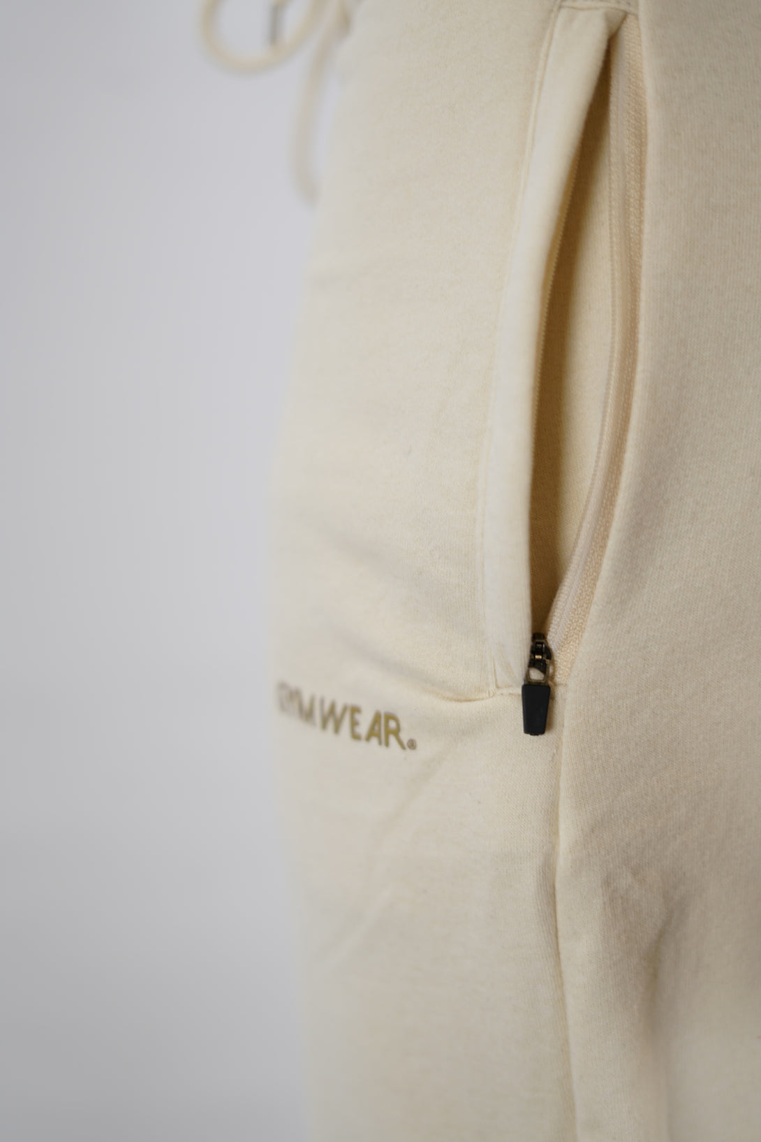 Träningsbyxor för herr i borstad bomull beige med Gymwear logga på vänster lår nedanför fickan, dragsko och elastisk midja