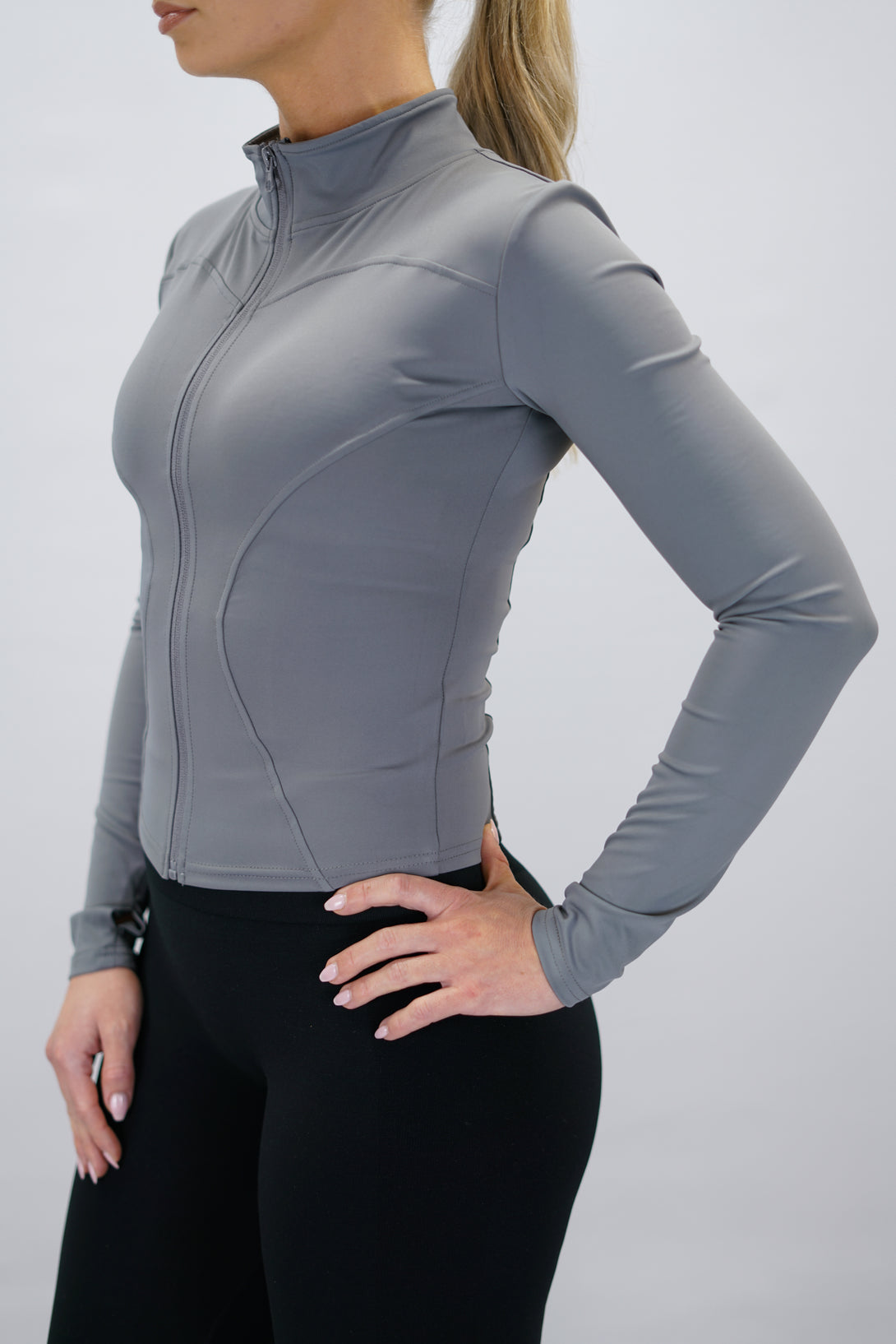 Grå Nalia Performance Long Sleeve Zipper Top - långärmad funktionströja med hel dragkedja, tumhål och Gymwear-logga i nacken