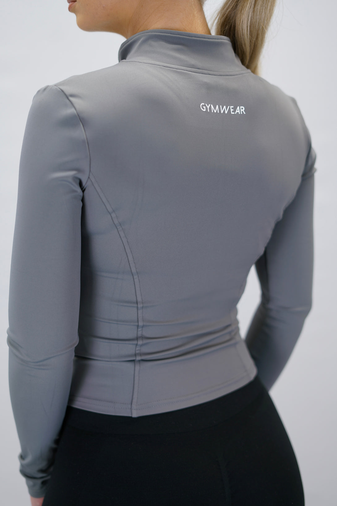 Grå Nalia Performance Long Sleeve Zipper Top - långärmad funktionströja med hel dragkedja, tumhål och Gymwear-logga i nacken