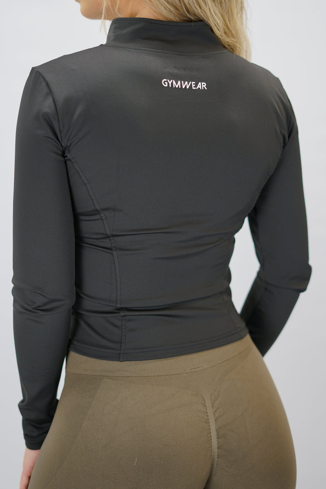 Svart Nalia Performance Long Sleeve Zipper Top - långärmad funktionströja med hel dragkedja, tumhål och Gymwear-logga i nacken