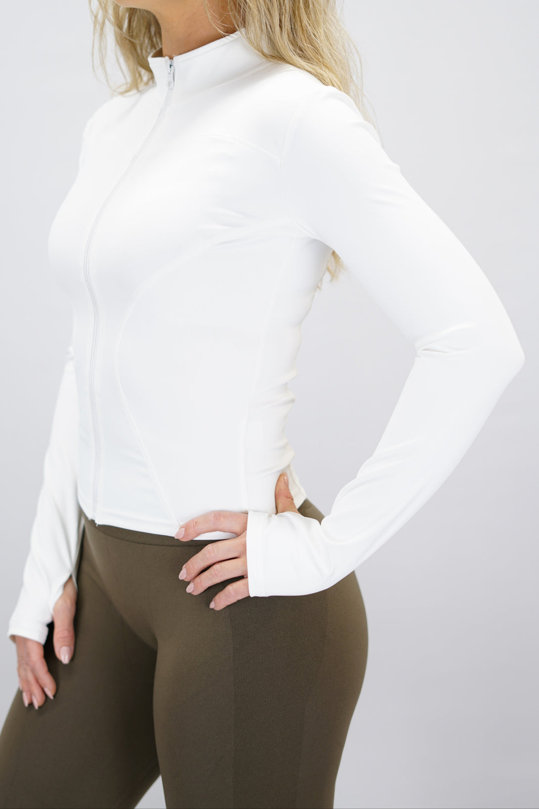 Vit Nalia Performance Long Sleeve Zipper Top - långärmad funktionströja med hel dragkedja, tumhål och Gymwear-logga i nacken